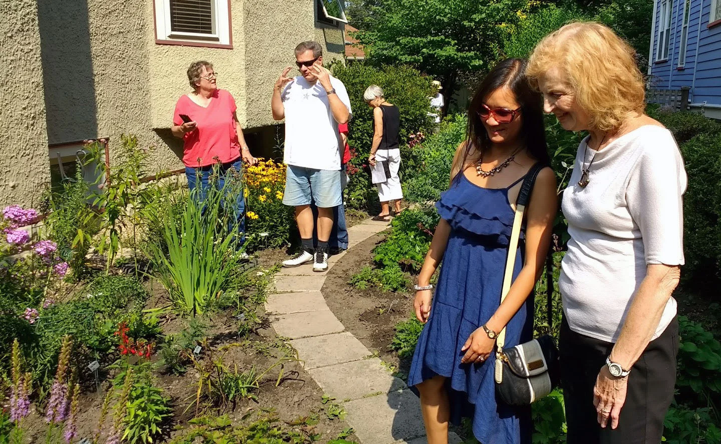 Mary Ann DeBruin (far right) shows her native plants to Michelle Cronin. Mary Ann's garden was one of 15 private and public native gardens on tour during peak season.