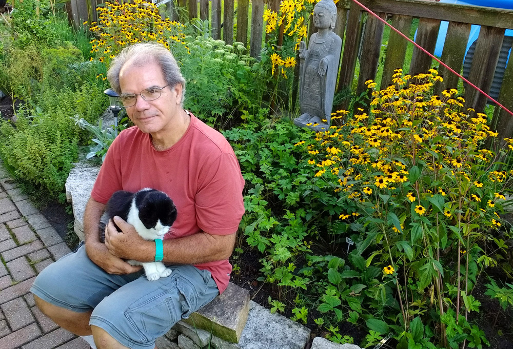 Jim Gill and his alley cat, Itchy, take a break near native blue mountain mint and brown-eyed Susan.