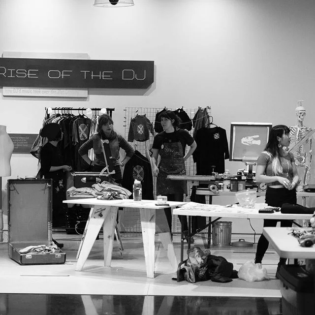 Great shot of the Embellishment live printing booth crew at Extracurricular! Check out the Anchorage Museum&rsquo;s blog to read a Q&amp;A on printmaking, zines, and community 🗣 We are out and about a lot lately, come see us this Saturday at ABC Ele