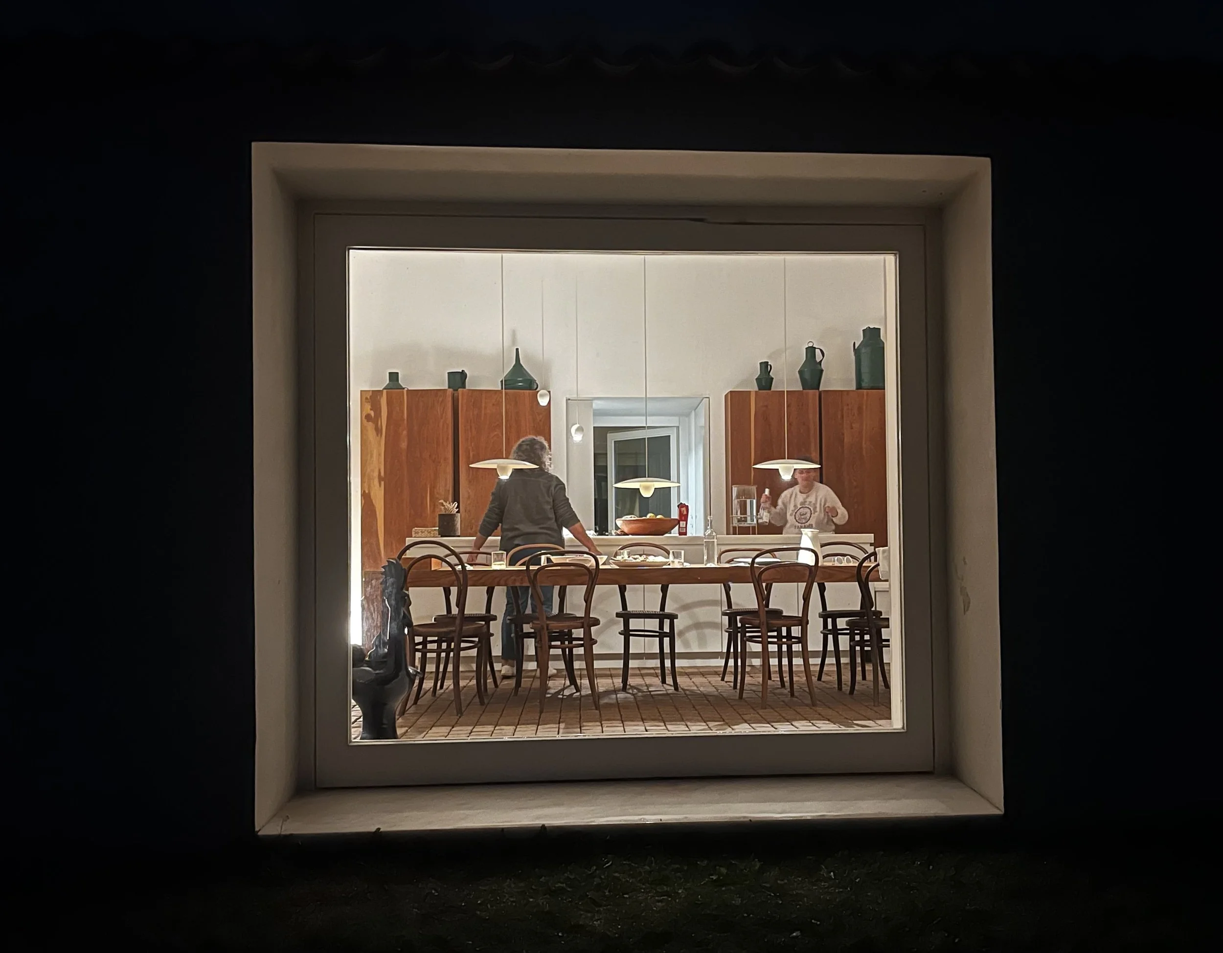 Standing outside looking into the kitchen all lit up