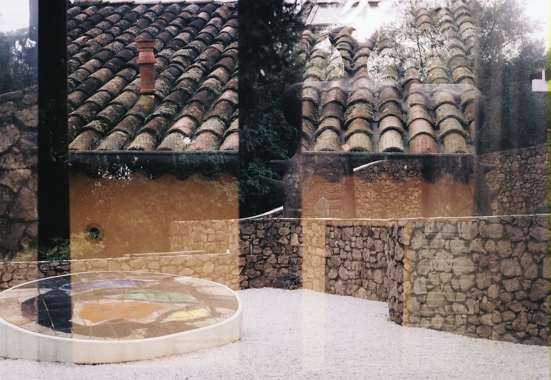 Double exposure terra cotta roof tiles and stone wall