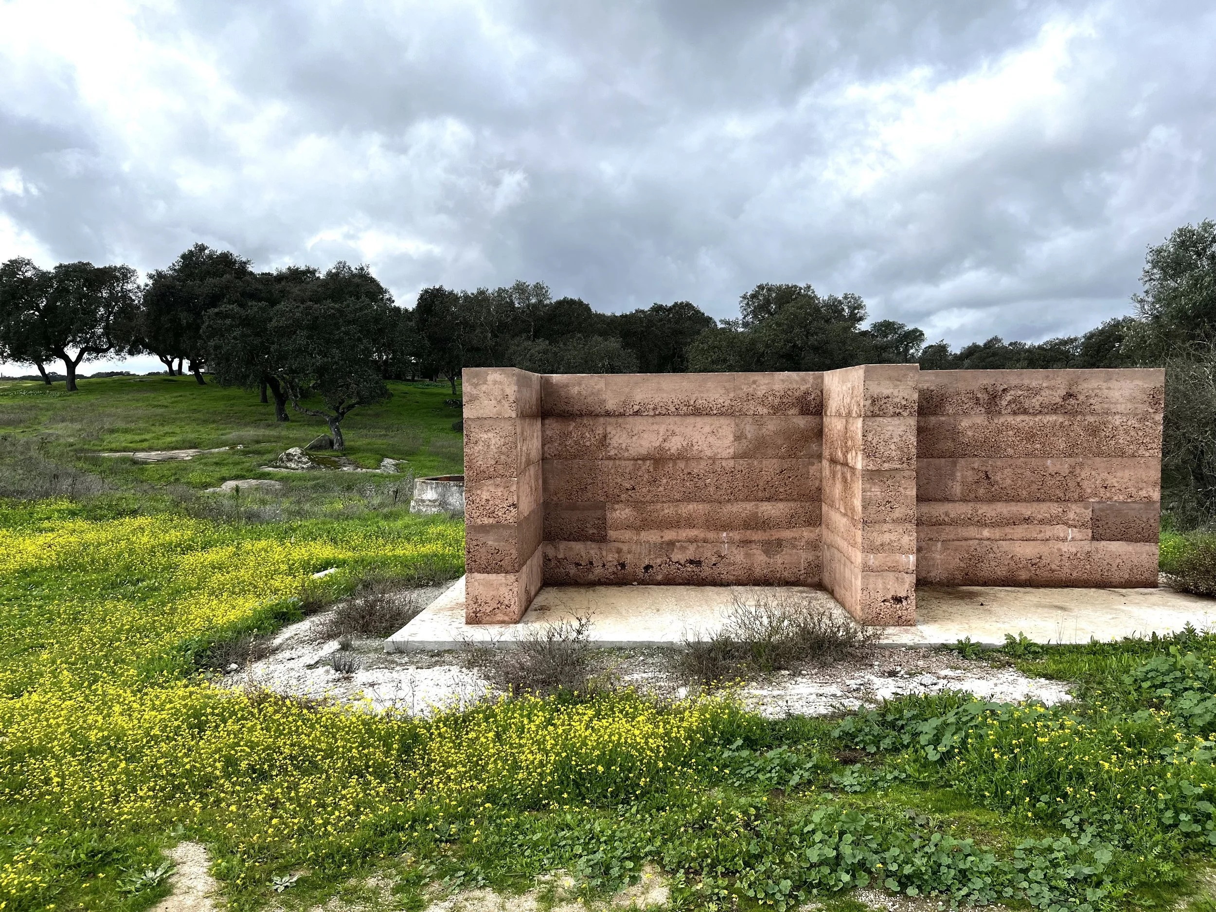 cement and earthen wall set admist the rolling green hills
