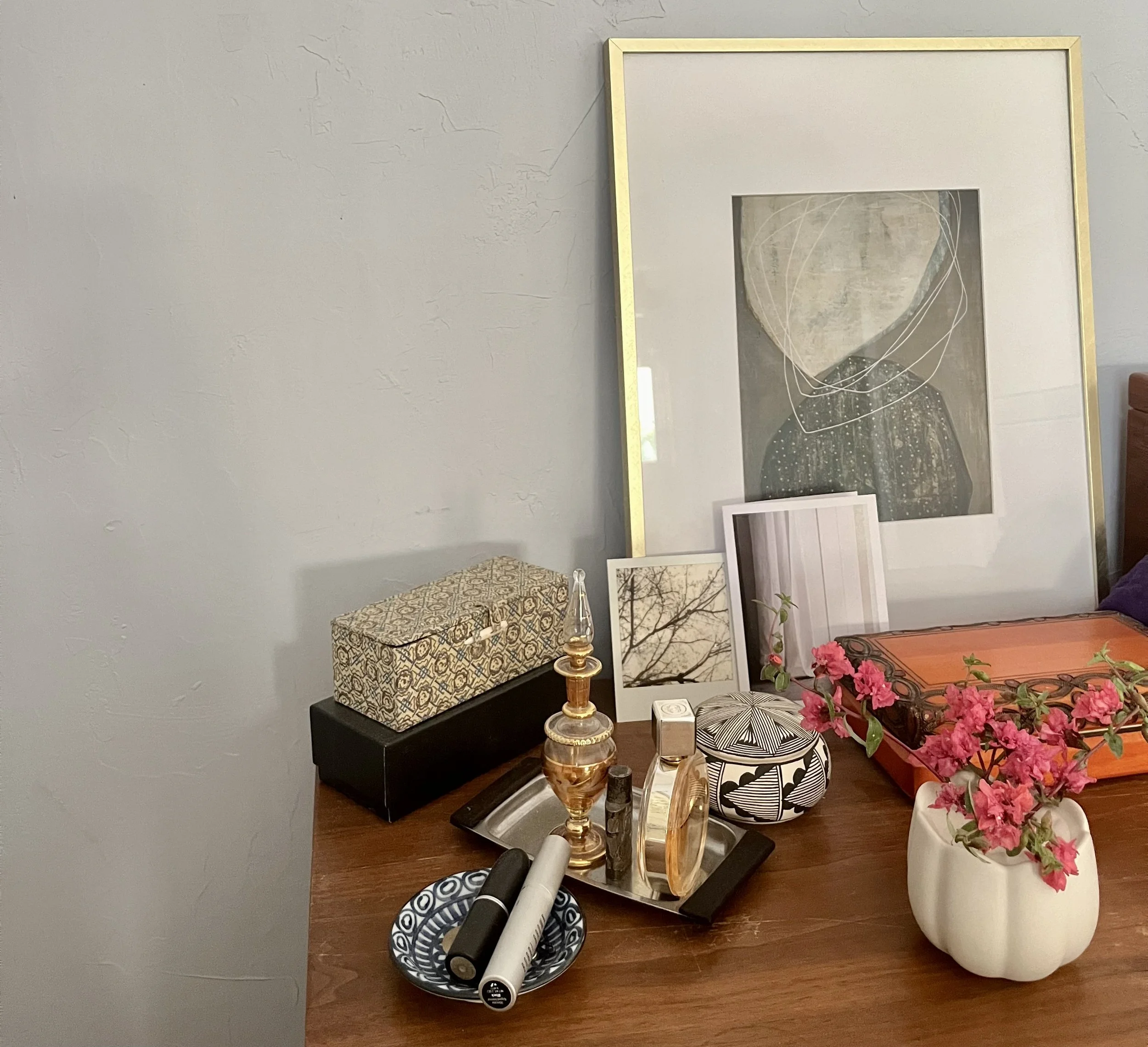 top of dresser with perfume, bottles, flowers, make-up