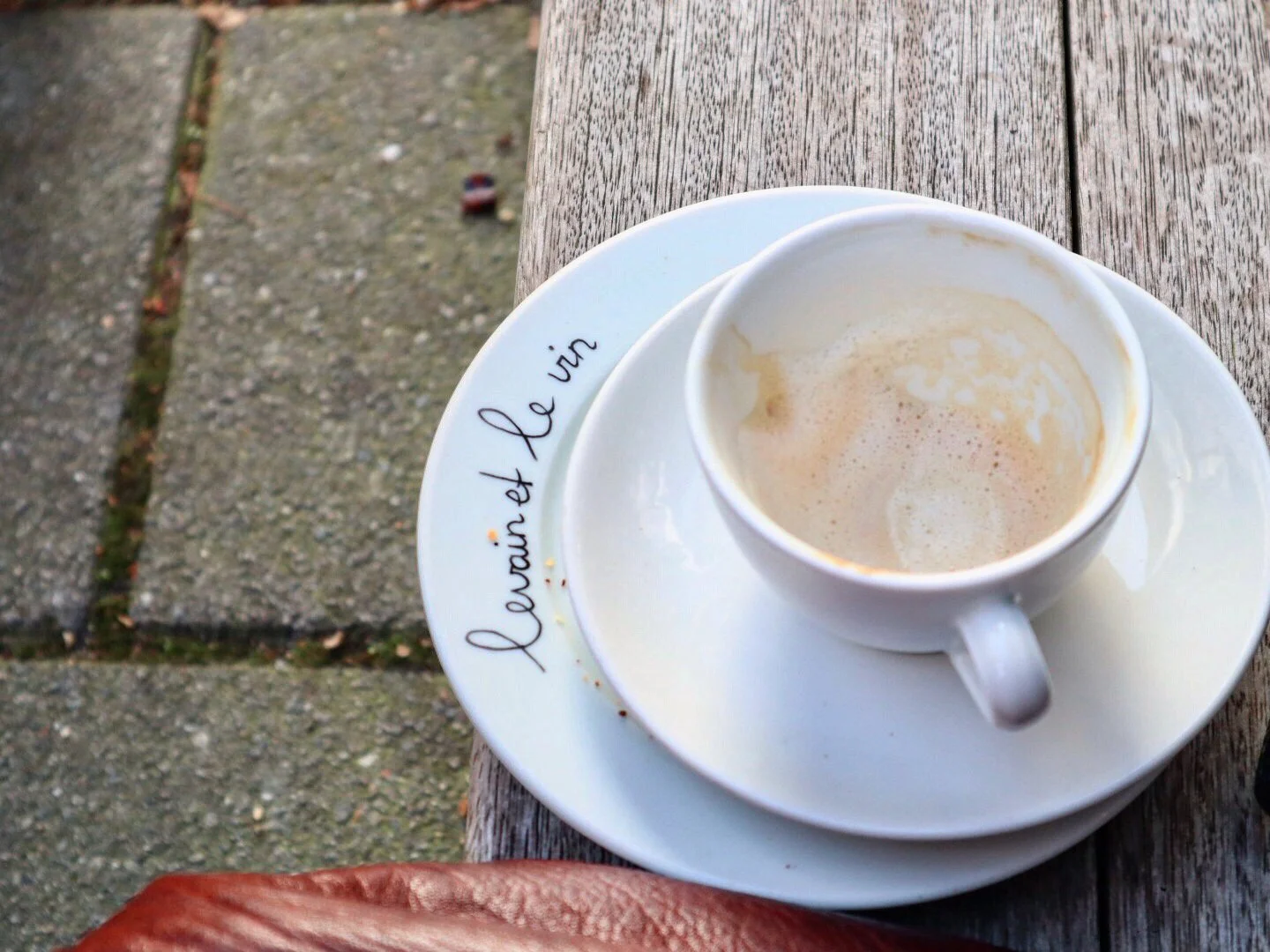 Empty cappuccino cup on a bench