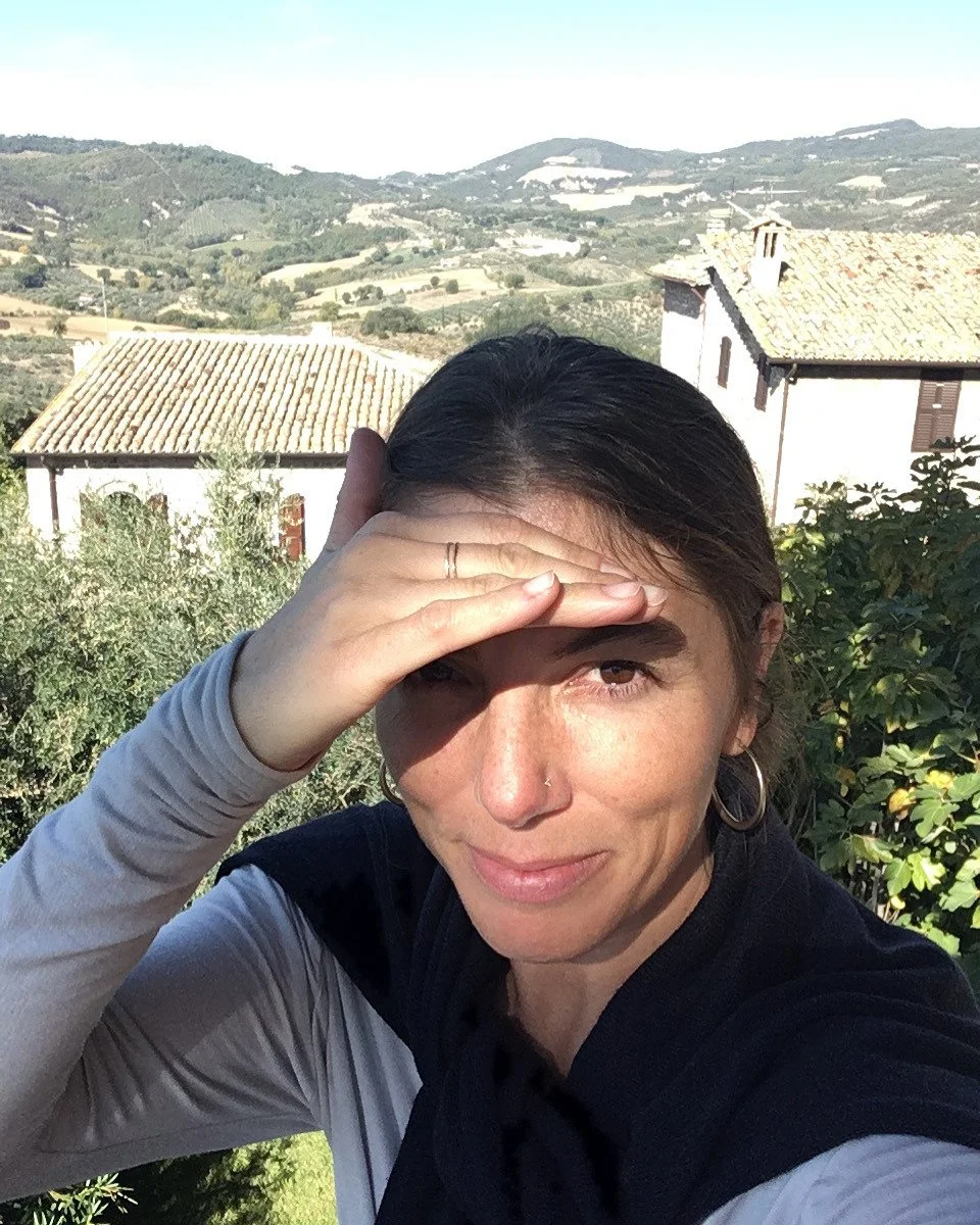 Young white woman shielding her eyes while looking into the sun