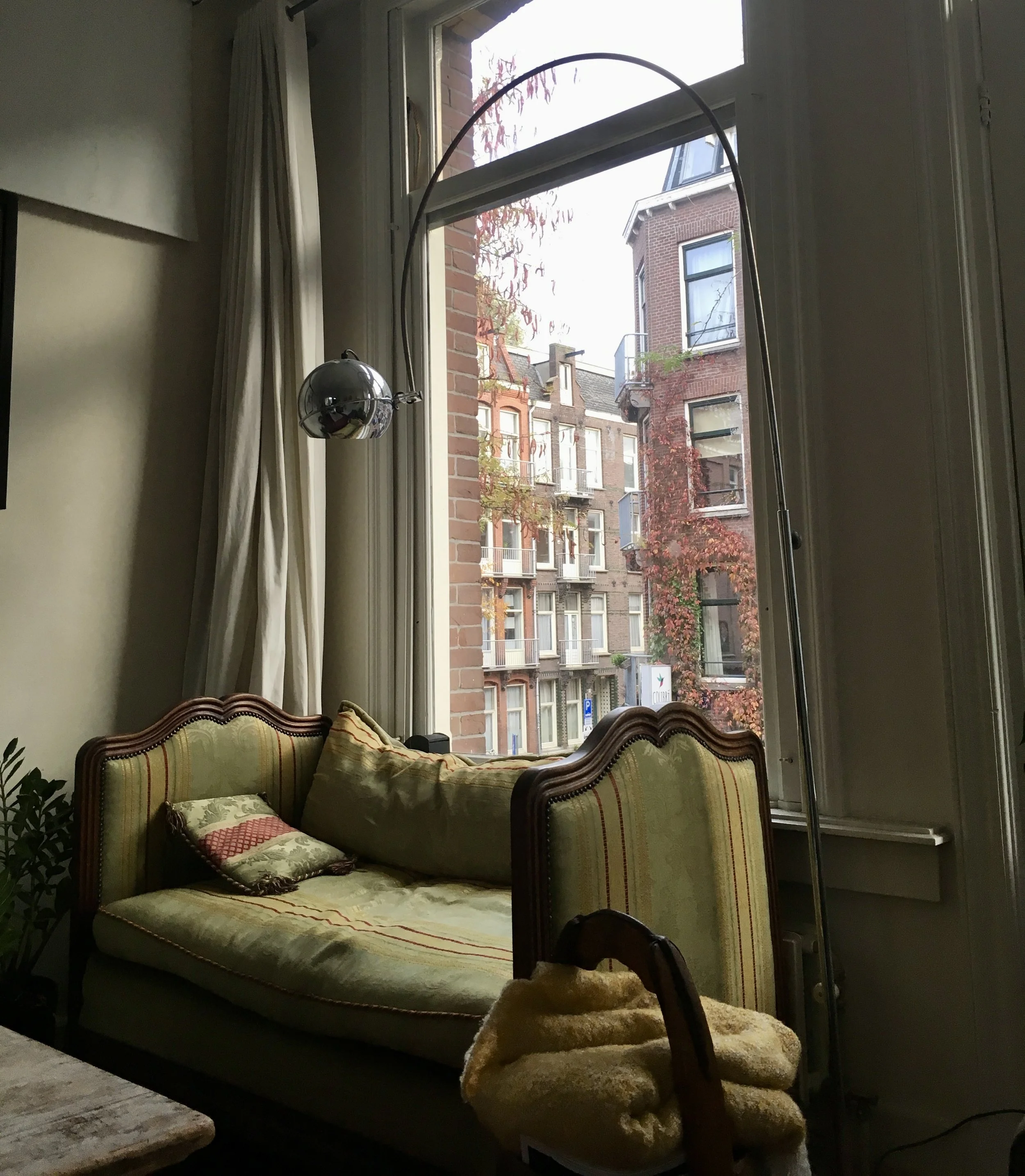 antique settee in front of a large window