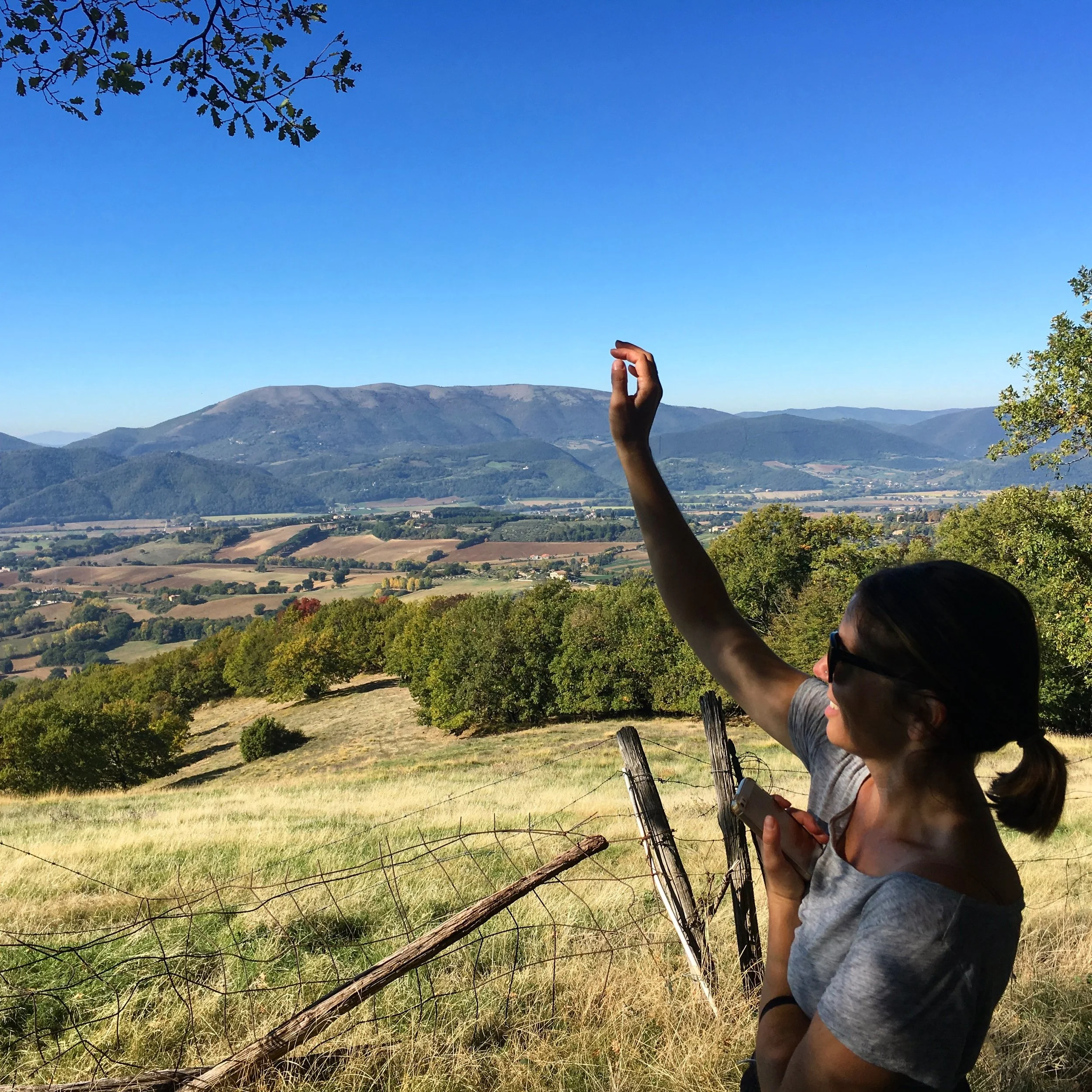 Woman with an arm raised to the sky while in the countryside