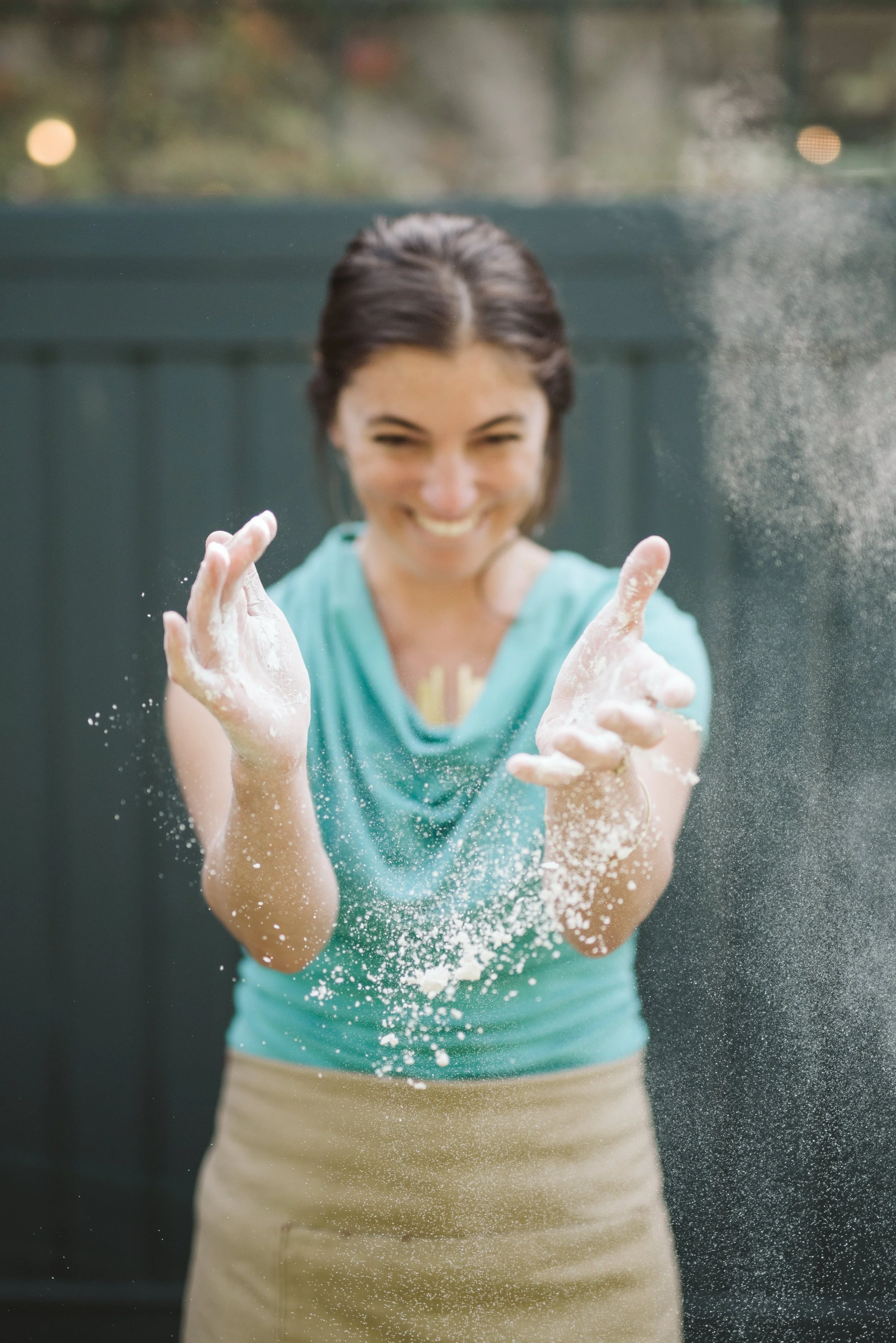 Woman with apron and floured hand clapping