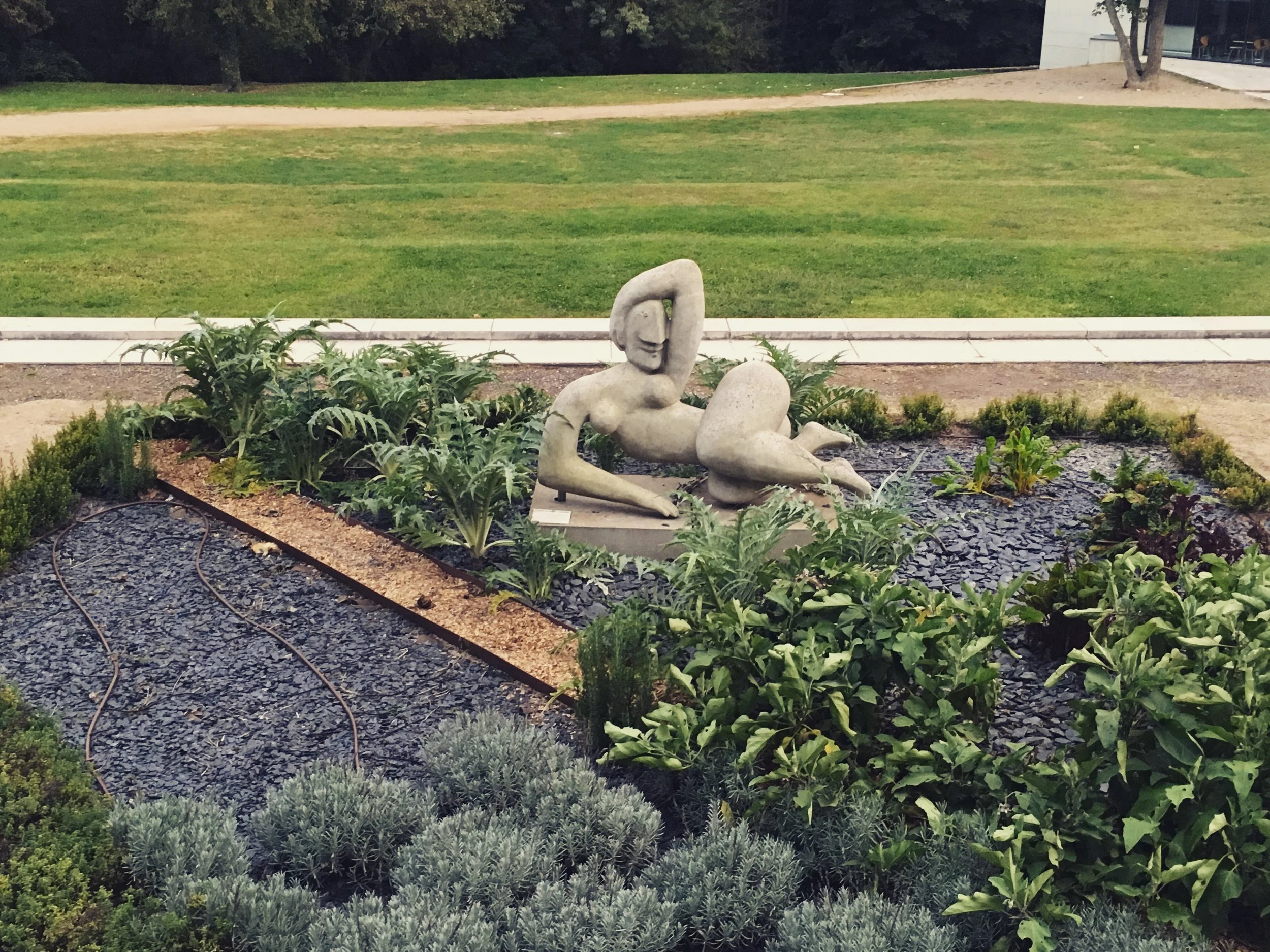 large statue of women lying on her side in the garden