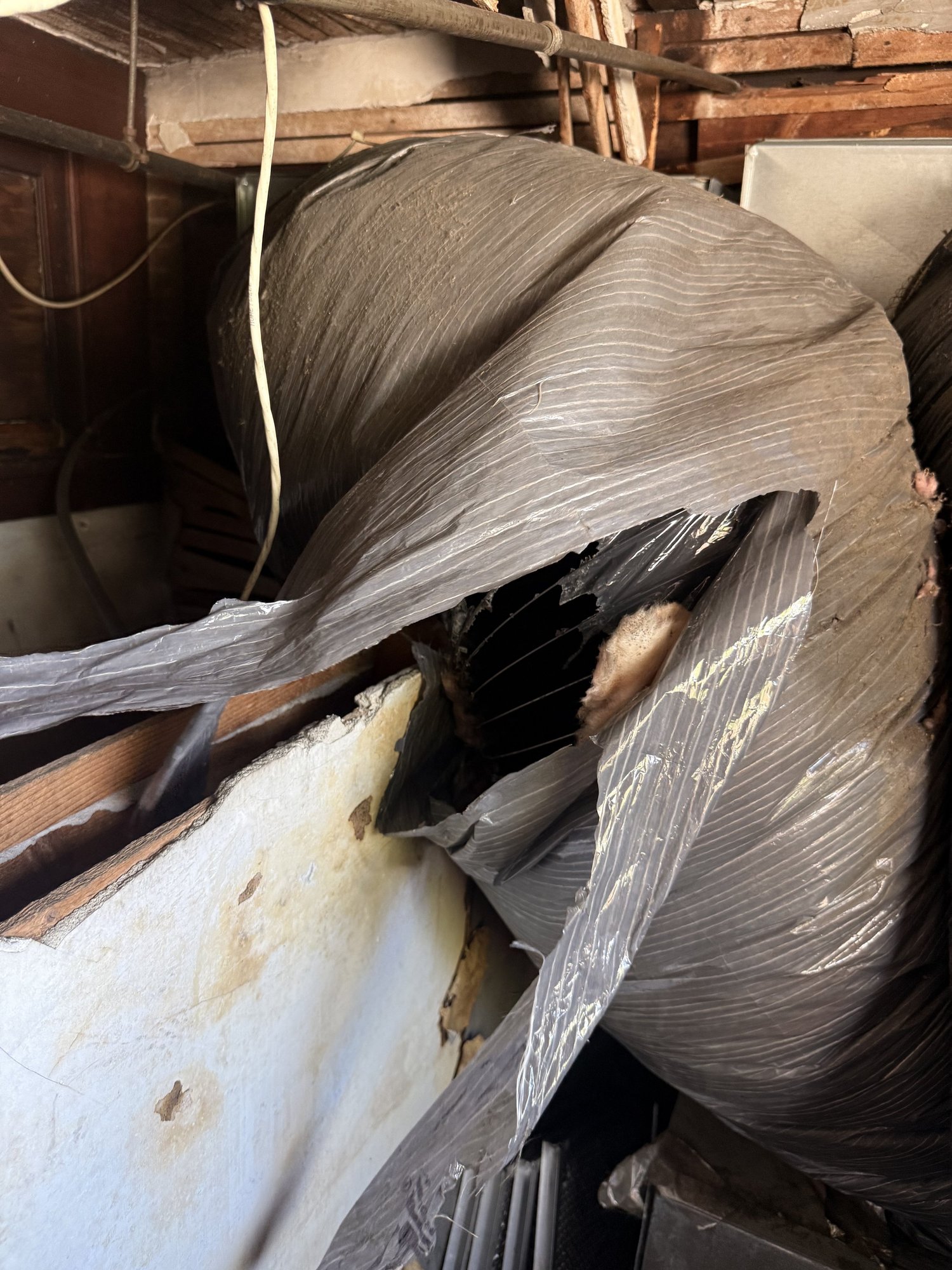 Severely torn 16-inch insulated flexible duct serving a rooftop system