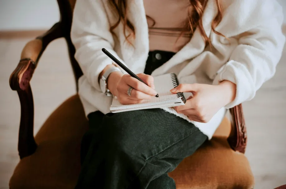 EMDR therapy session with a therapist seated comfortably while engaging in guided therapeutic exercises using a notebook in a calm clinical setting.