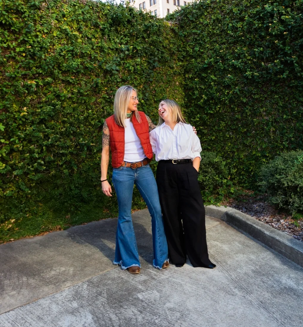 Iron City Counseling founders Jessica and Erica standing together outdoors in Birmingham, Alabama, sharing a candid moment that reflects a supportive and collaborative approach to mental health care.