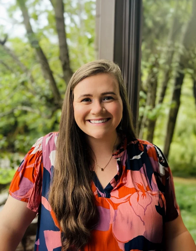 Raygan Salors, licensed therapist at Iron City Counseling in Birmingham, Alabama, smiling in a natural light portrait and offering supportive mental health care for individuals, couples, and families.