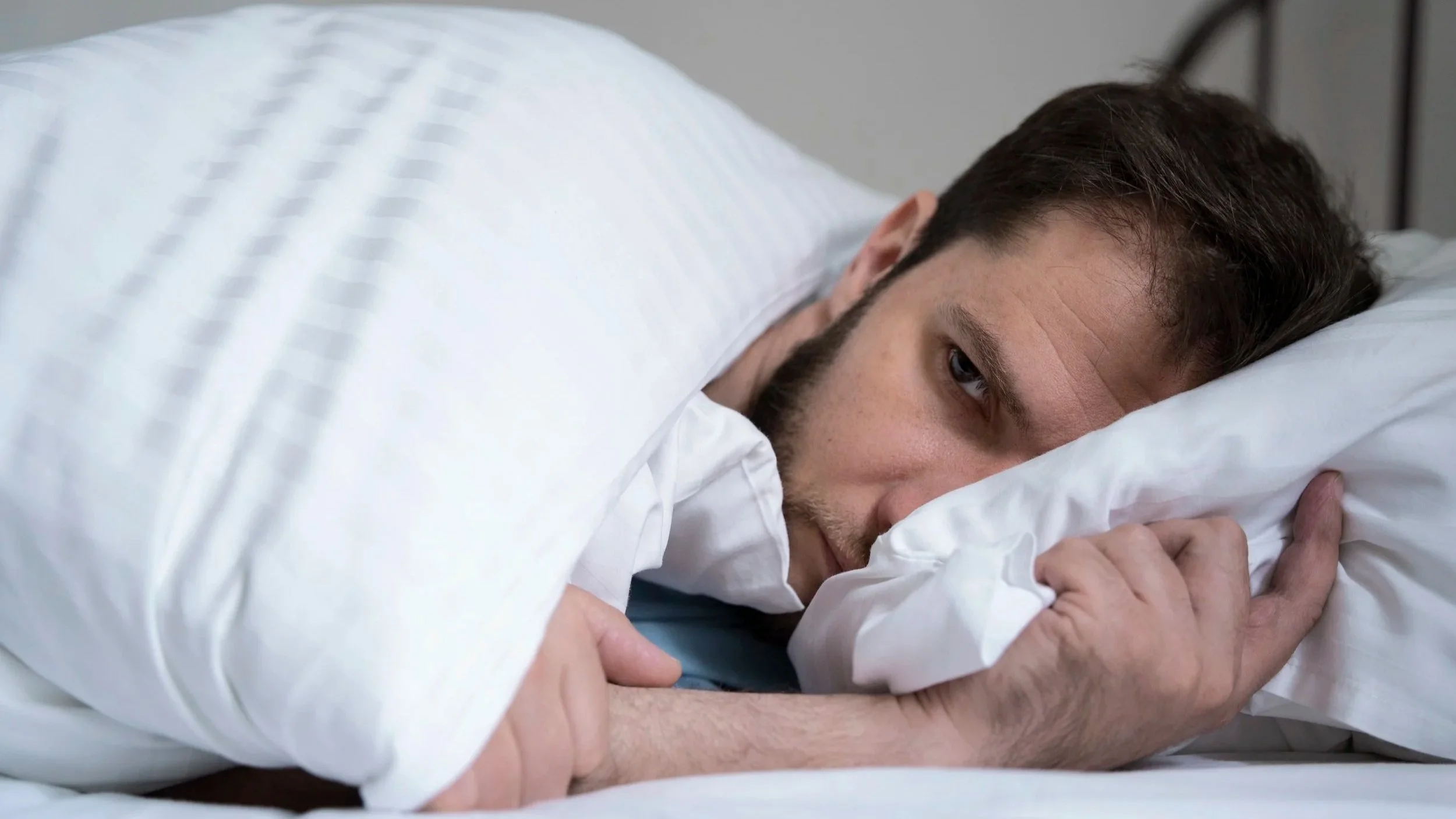Person waking up tired and unrefreshed due to poor sleep quality