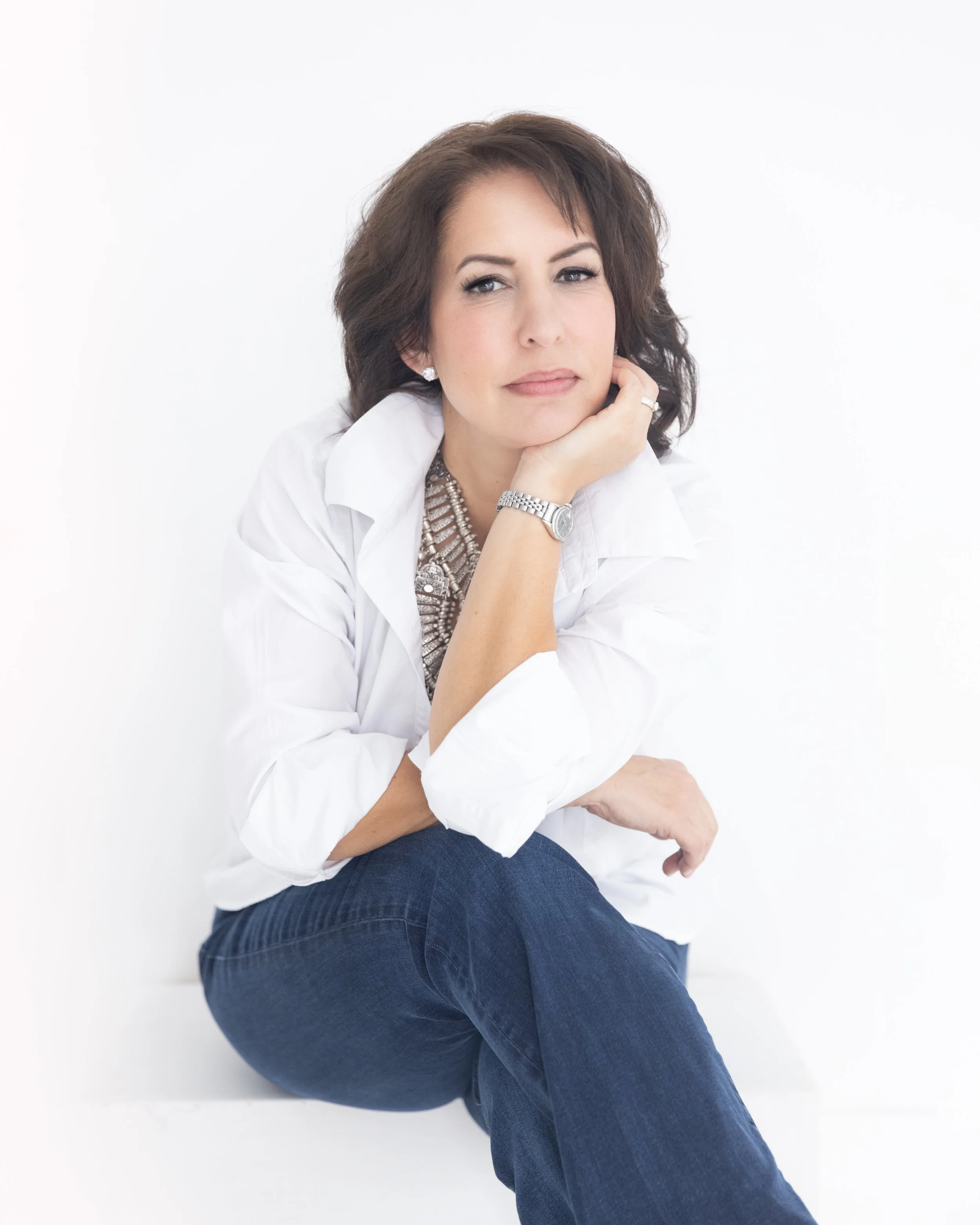 Jeans. A white blouse, one or two, or maybe even three buttons braver than her usual. A necklace that came to say something. Nothing on display she didn&rsquo;t choose to show, because the power was never about the neckline. Look at her face. That&rs