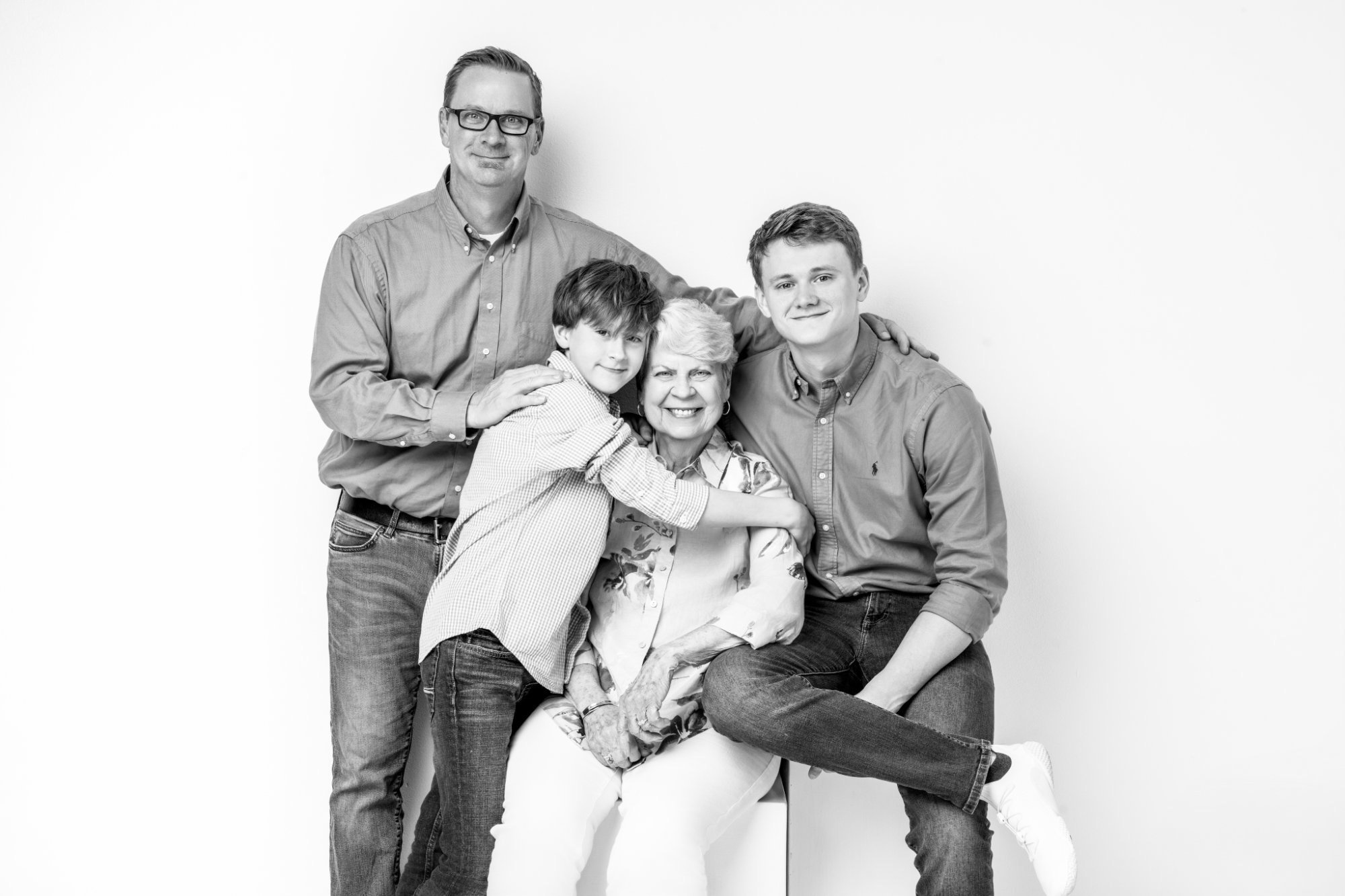 Black and white studio portrait of photographer Nicole Gates's husband, sons and mother in law, three generations, McAllen TX family photographer