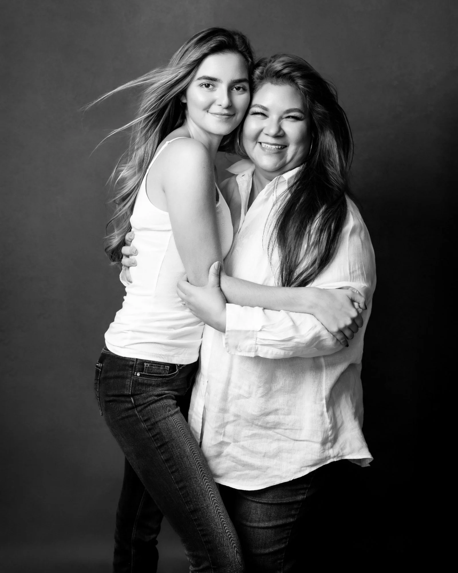 Black and white studio portrait of a mother and adult daughter embracing and smiling, McAllen TX mother daughter portrait photographer