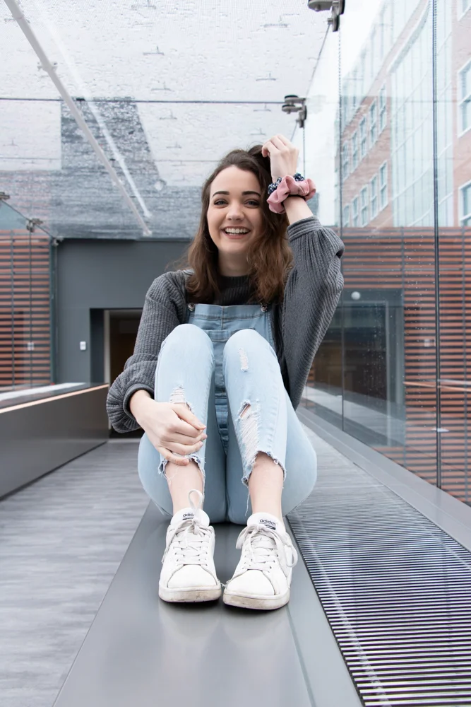 Magdalena Becker, a junior journalism major, sits in the Skywalk connecting Alter Hall and 1810 Liacouras Walk. | HANNAH PITTEL / REFINE MAGAZINE