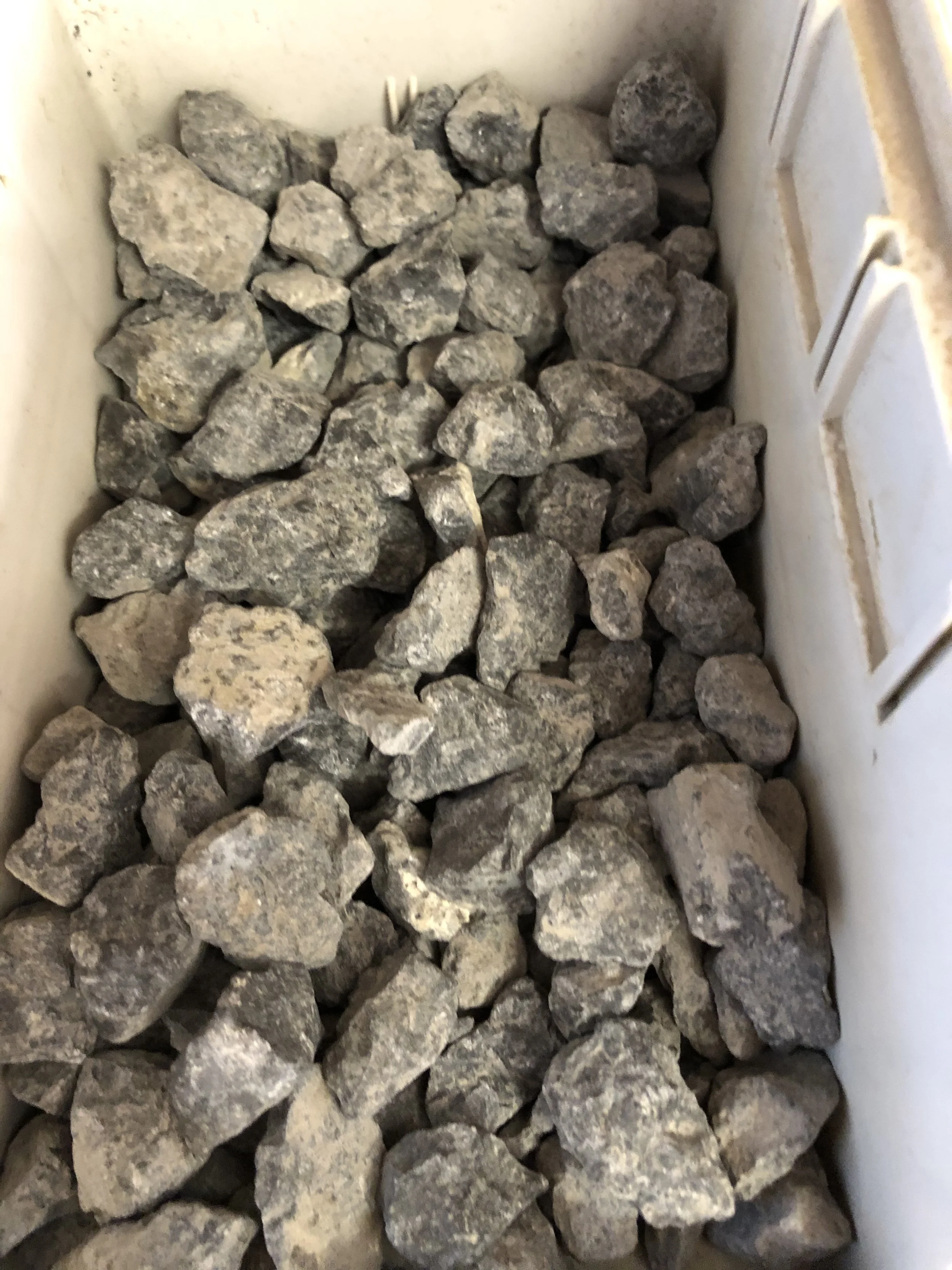 A bin filled with grayish, irregularly shaped rocks.