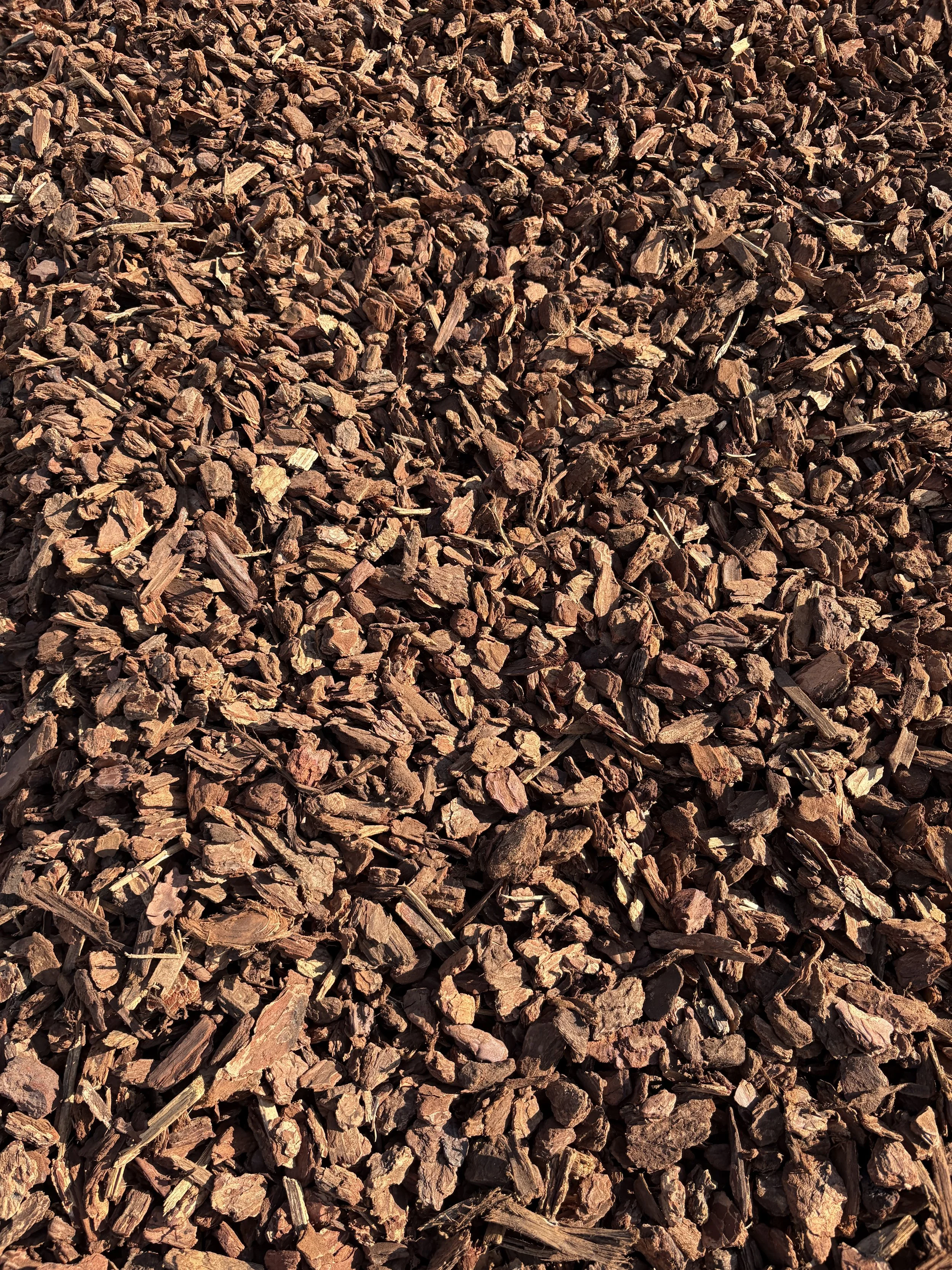 Close-up view of brown mulch or wood chips, often used for gardening or landscaping.