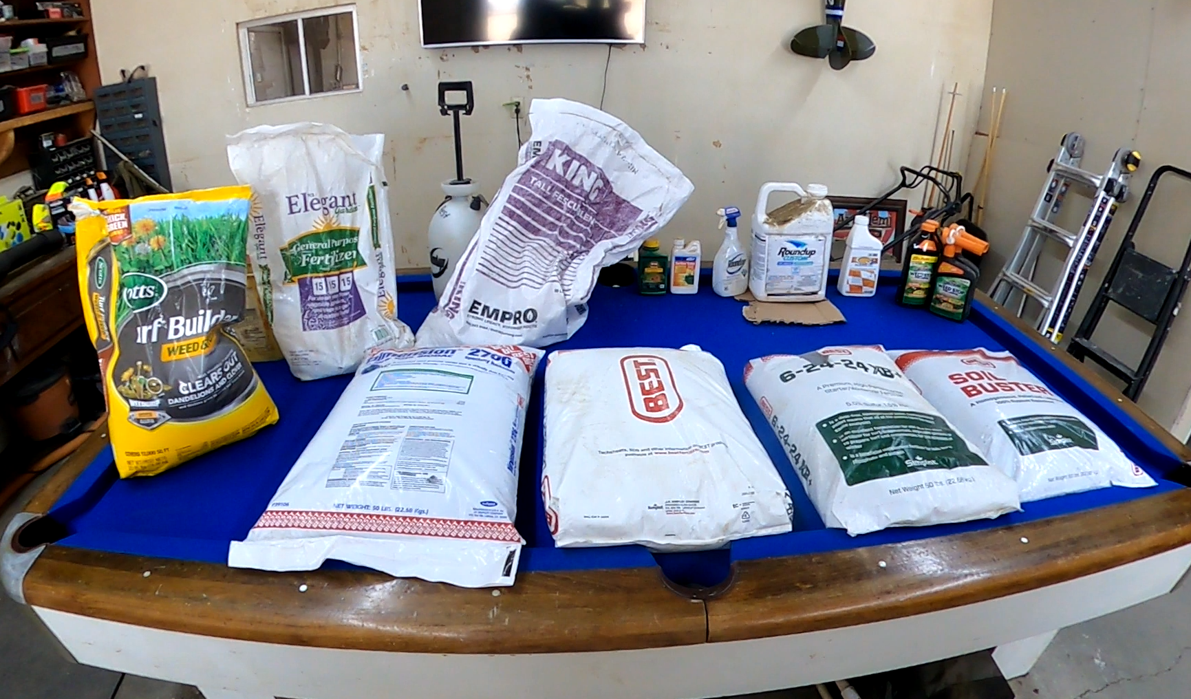 Bagged soil, fertilizer, and gardening supplies on a pool table.
