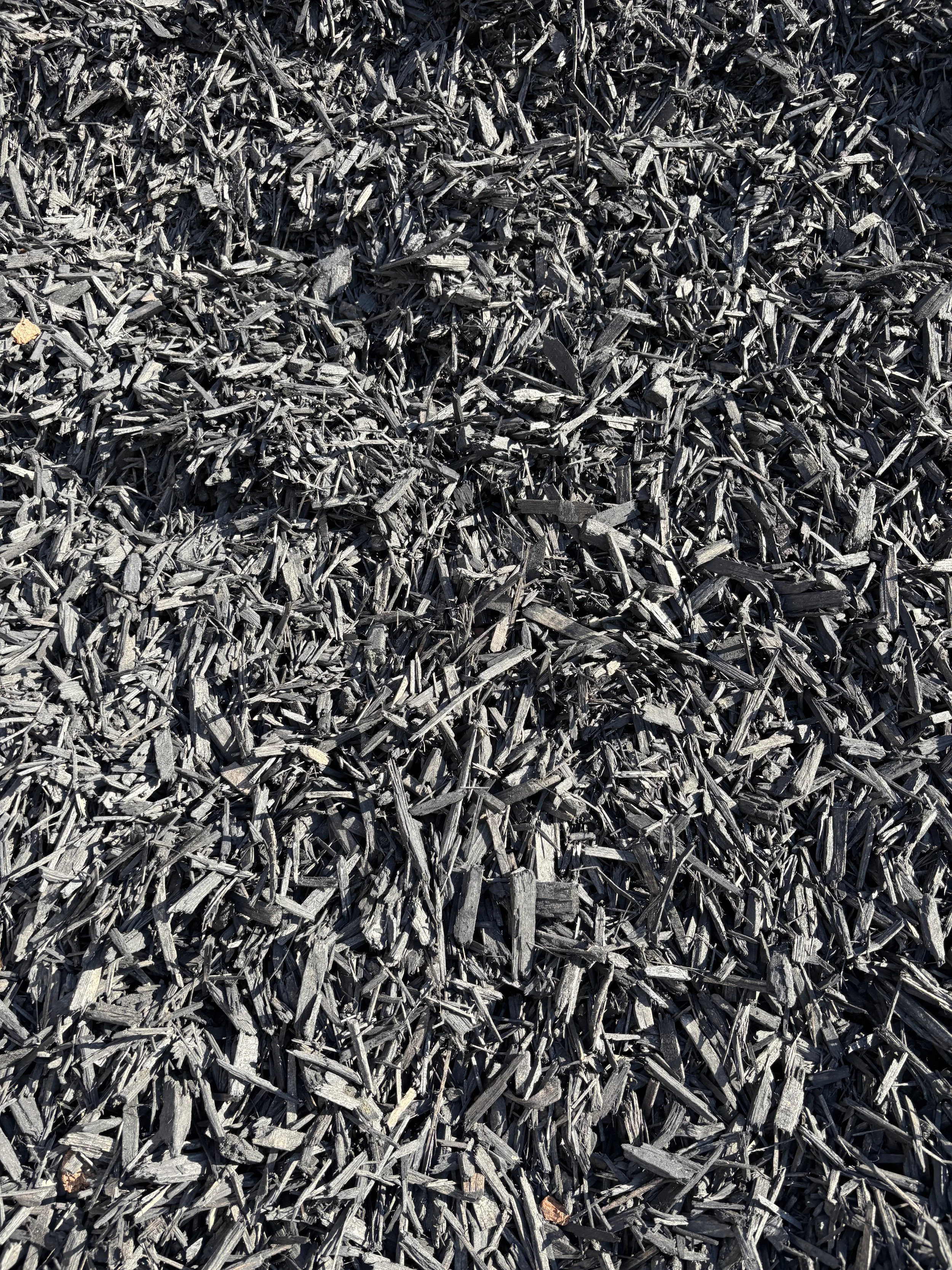 A pile of black wood chips or bark mulch.