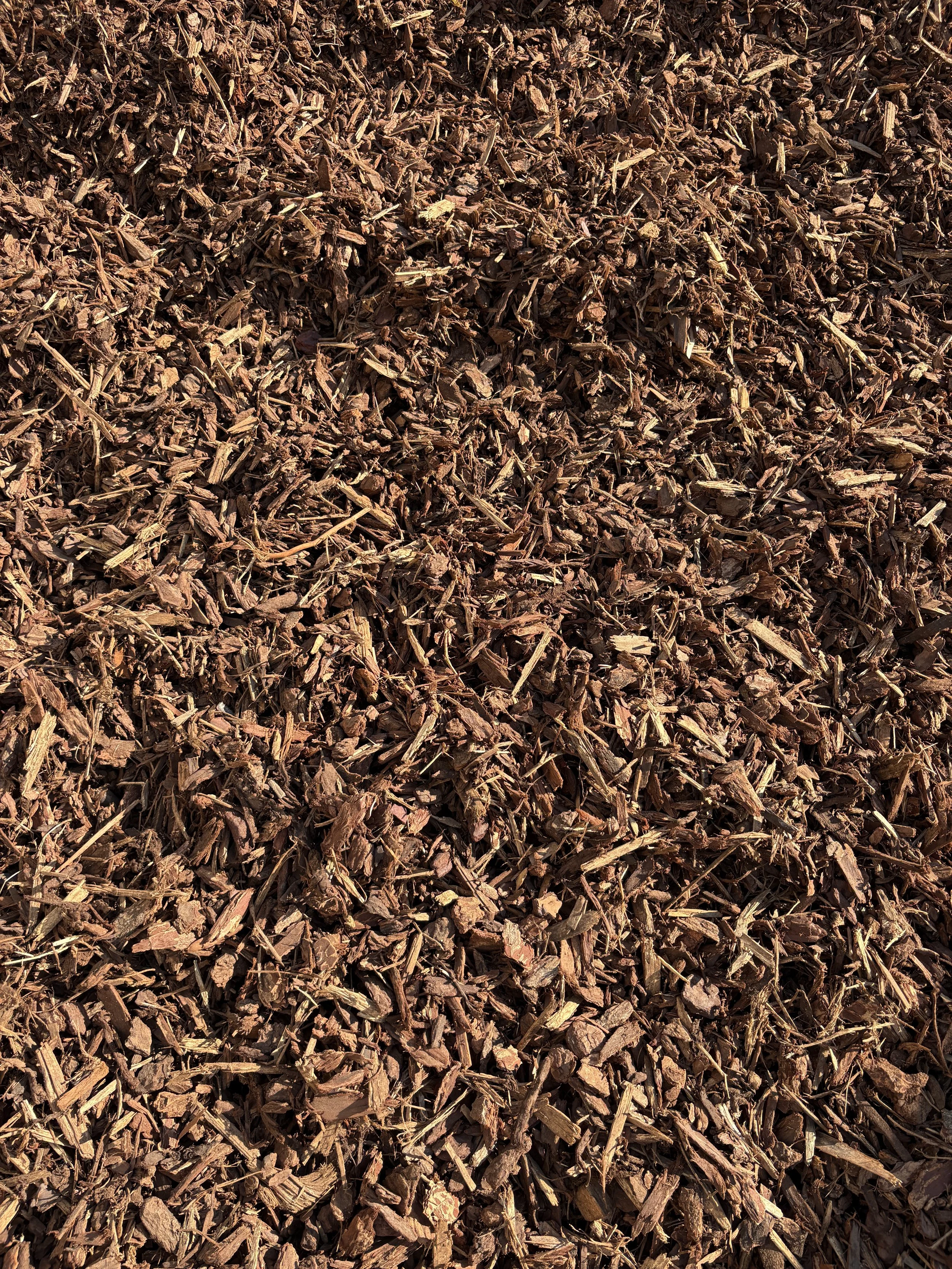 Close-up of a pile of shredded brown tree bark mulch.