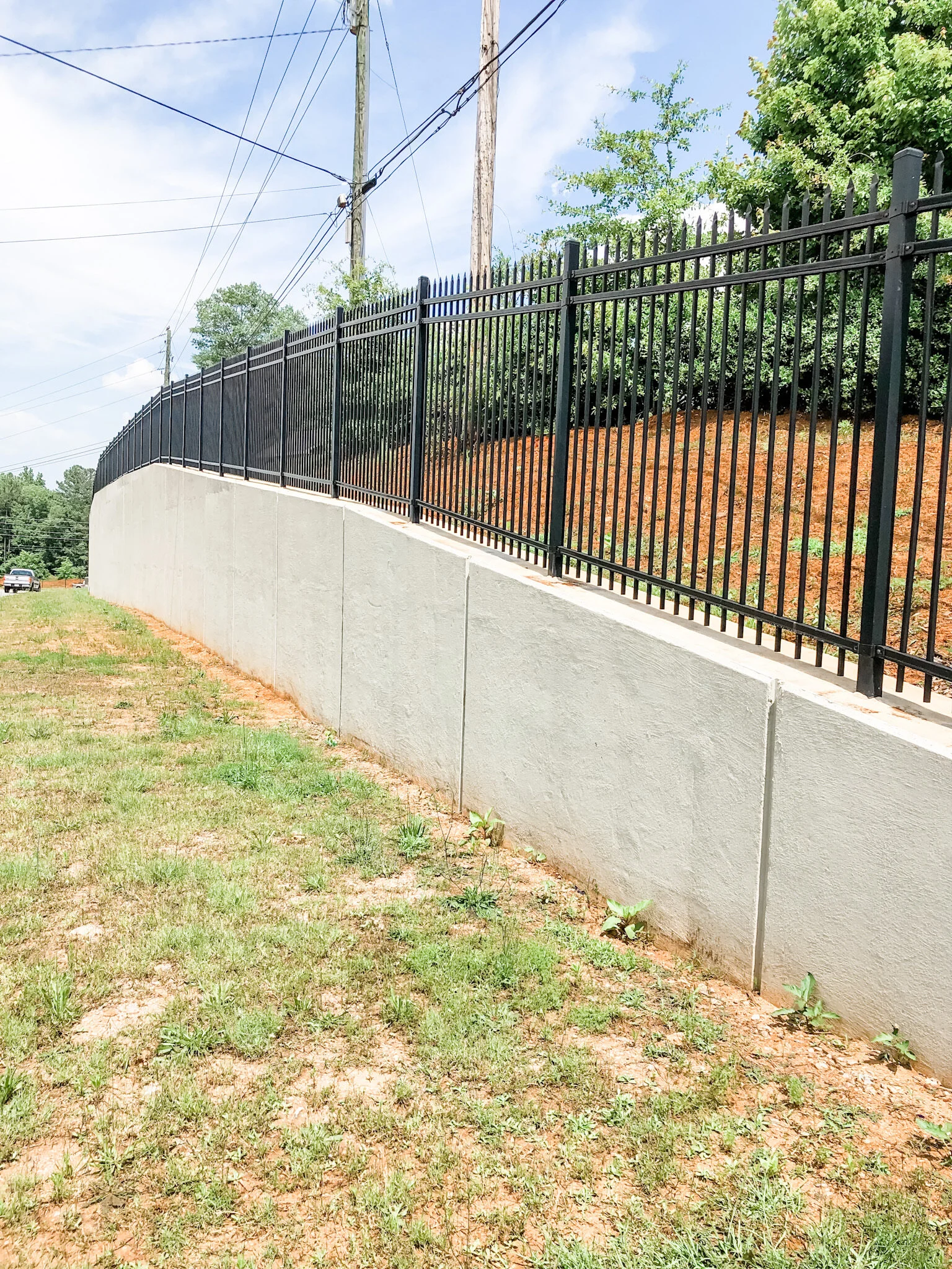 Ornamental fence installed in new concrete retaining wall.