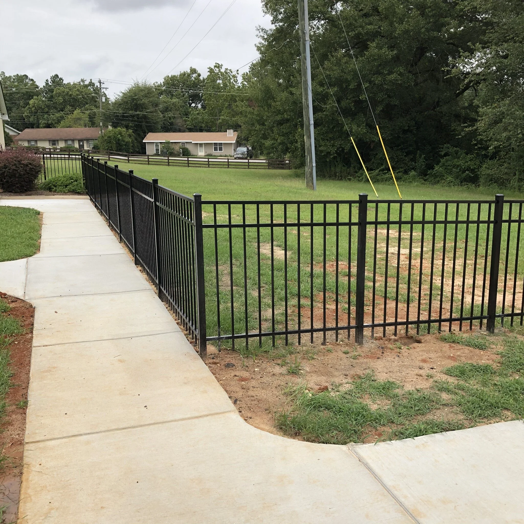 ornamental aluminum fence with concrete sidewalk.jpeg