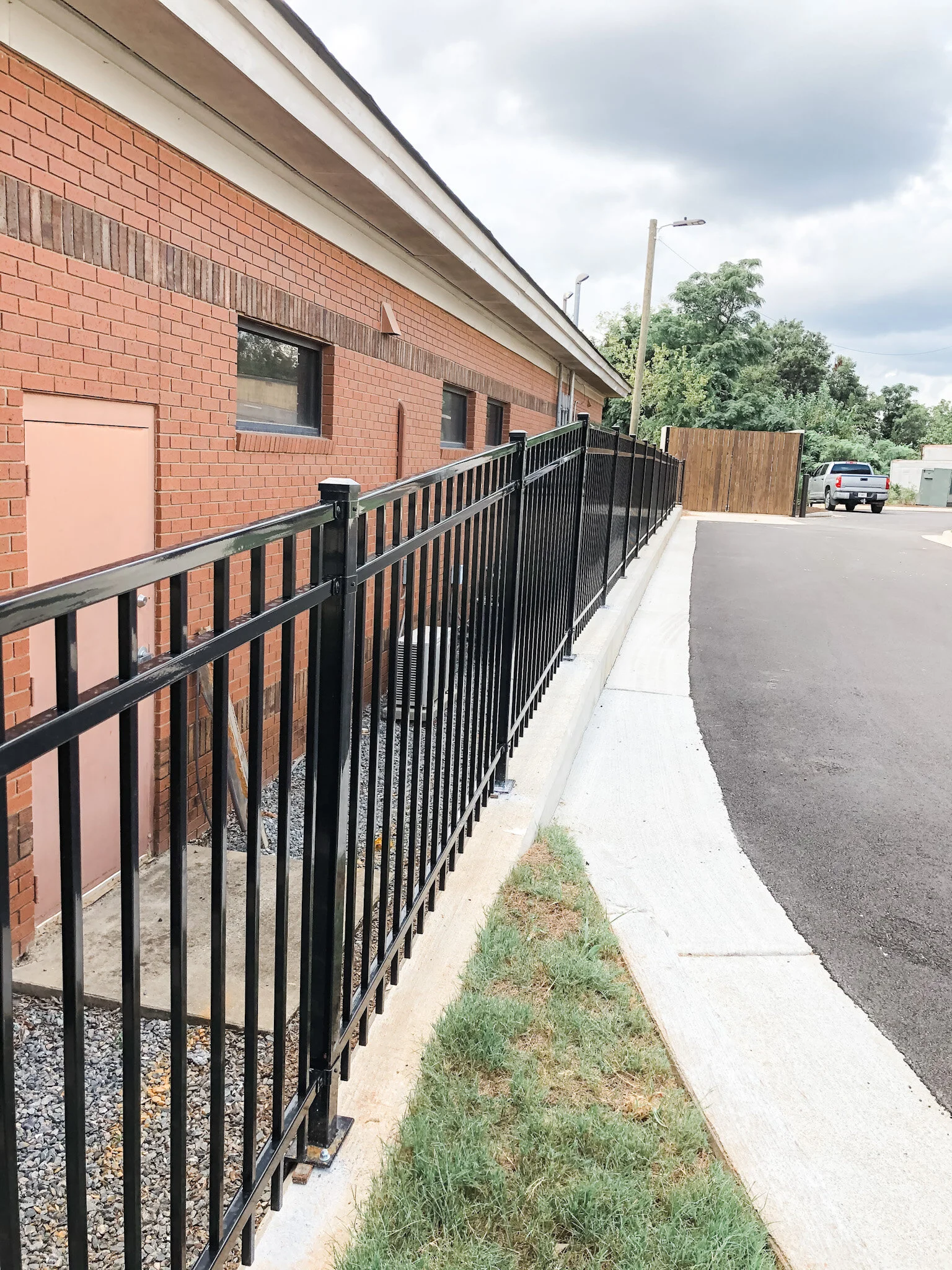ornamental perimeter boundary fence on concrete cement curb.jpeg