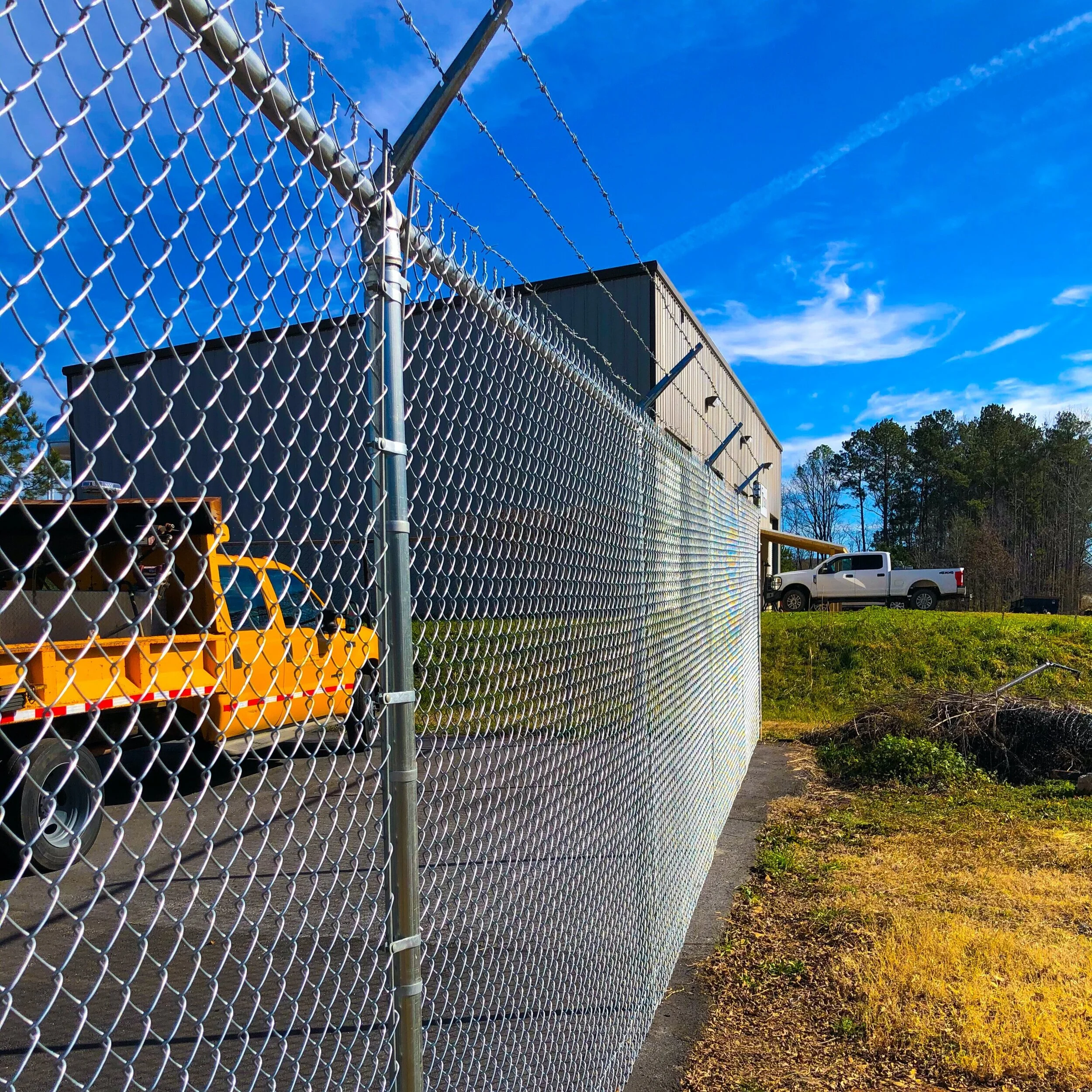 Six foot chain link perimeter fence with barbed wire.