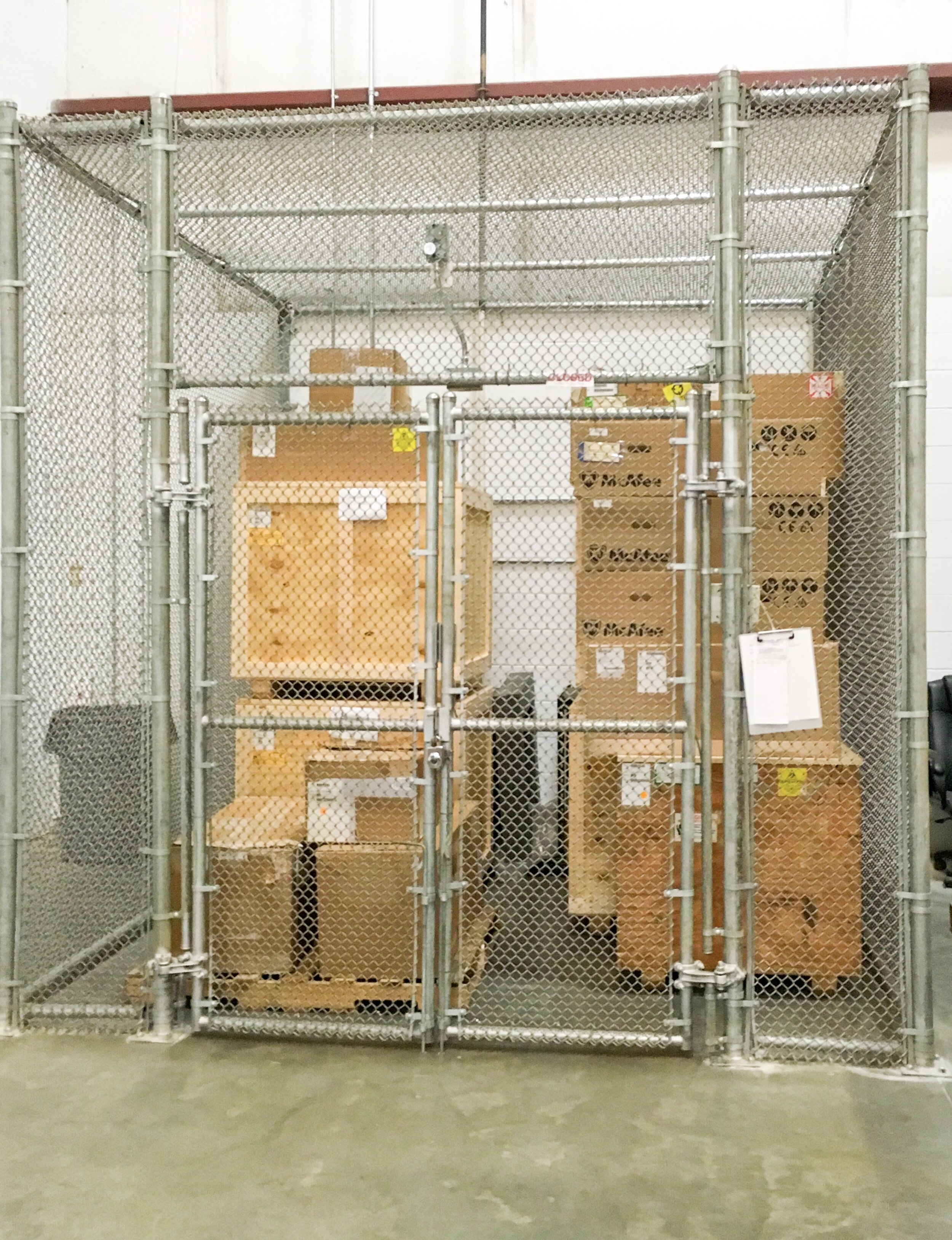 Indoor all sides chain link security cage installed in concrete.