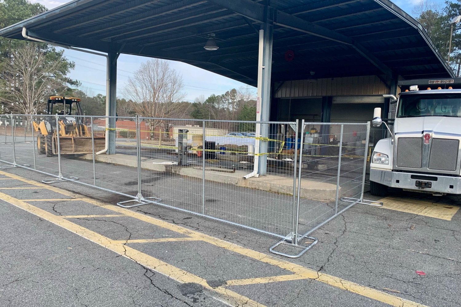 Temporary fence panels securing a work area beside a covered loading bay