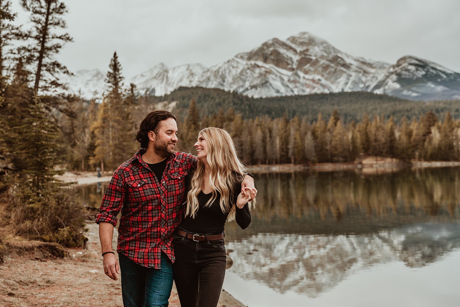Man and woman walking on a beach with Pyramid Mountain behind them | Jamie Robson Photography | Engagement Photographer in Jasper (Copy)