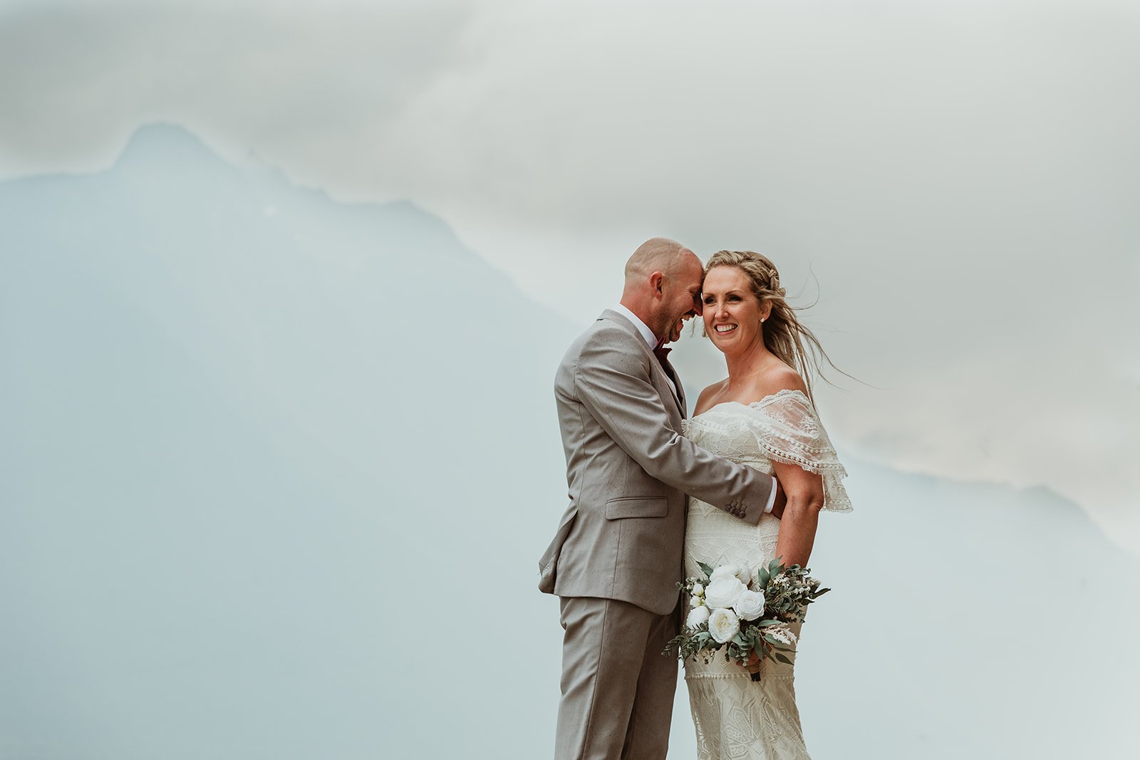 Bride & Groom with faint mountains in the back Kinabasket Lake in Valemeount | Jamie Robson Photography | Elopement & Wedding Photographer in Jasper (Copy)