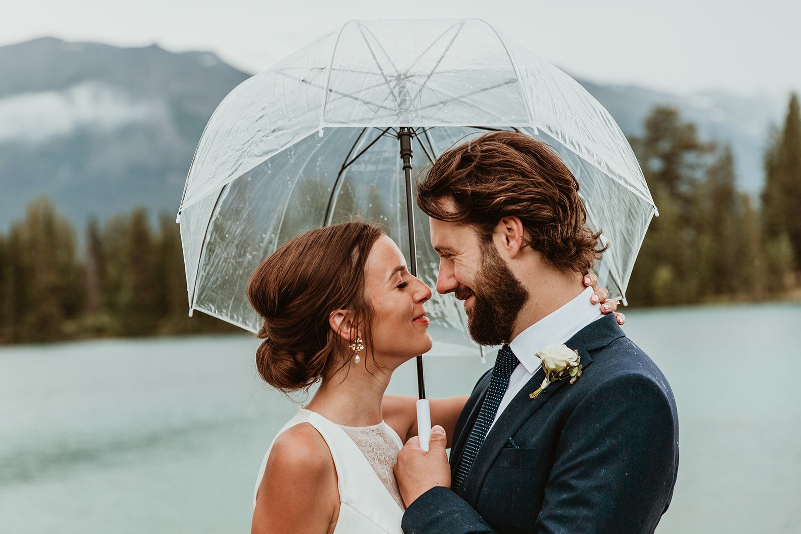 Bride & Groom under umbrella at Lac Beauvert, Jasper Park Lodge Wedding | Jamie Robson Photography | Elopement & Wedding Photographer in Jasper (Copy)