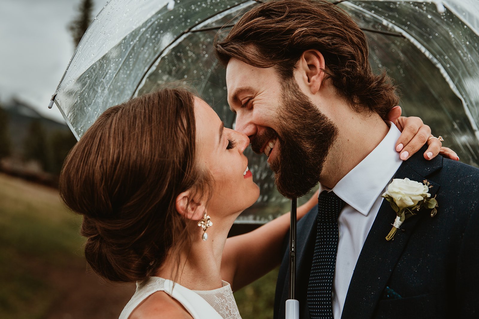 Bride & Groom kissing under umbrella at Jasper Park Lodge Wedding | Jamie Robson Photography | Elopement & Wedding Photographer in Jasper (Copy)