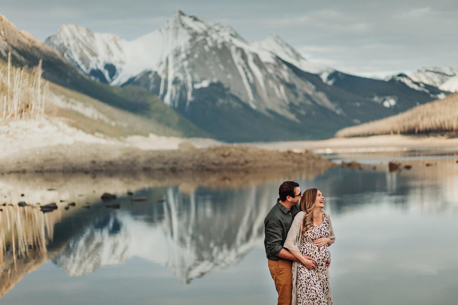 Man and Pregnant woman laughing at Medicine Lake | Jamie Robson Photography | Maternity Photographer in Jasper (Copy)
