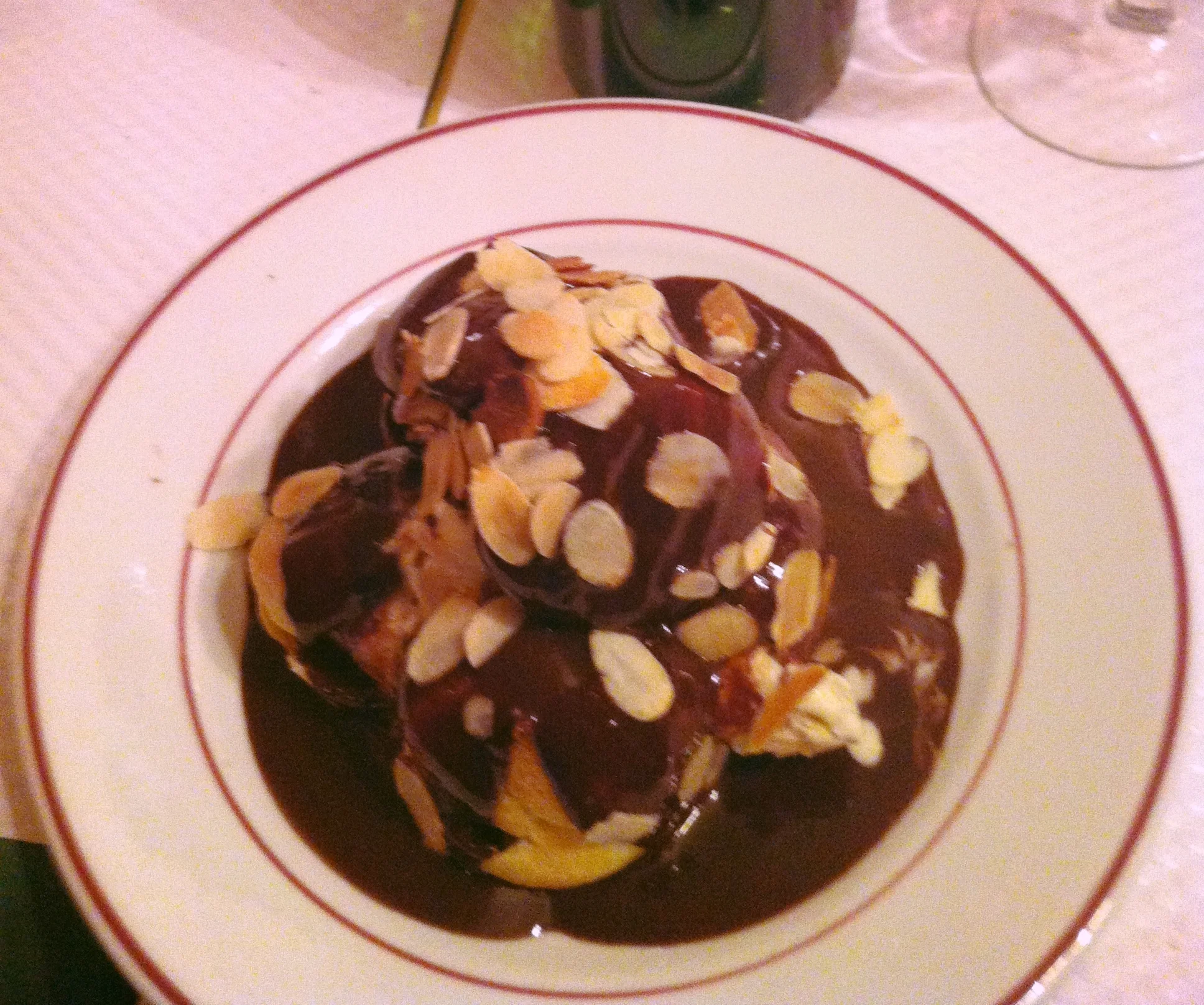 CHOCOLATE PROFITEROLES - ONE OF THEIR MOST POPULAR DESSERTS: DELICIOUS DONUT LIKE CAKES WITH VANILLA ICE CREAM, ALL SPRINKLED WITH HOT CHOCOLATE AND TOASTED ALMONDS.