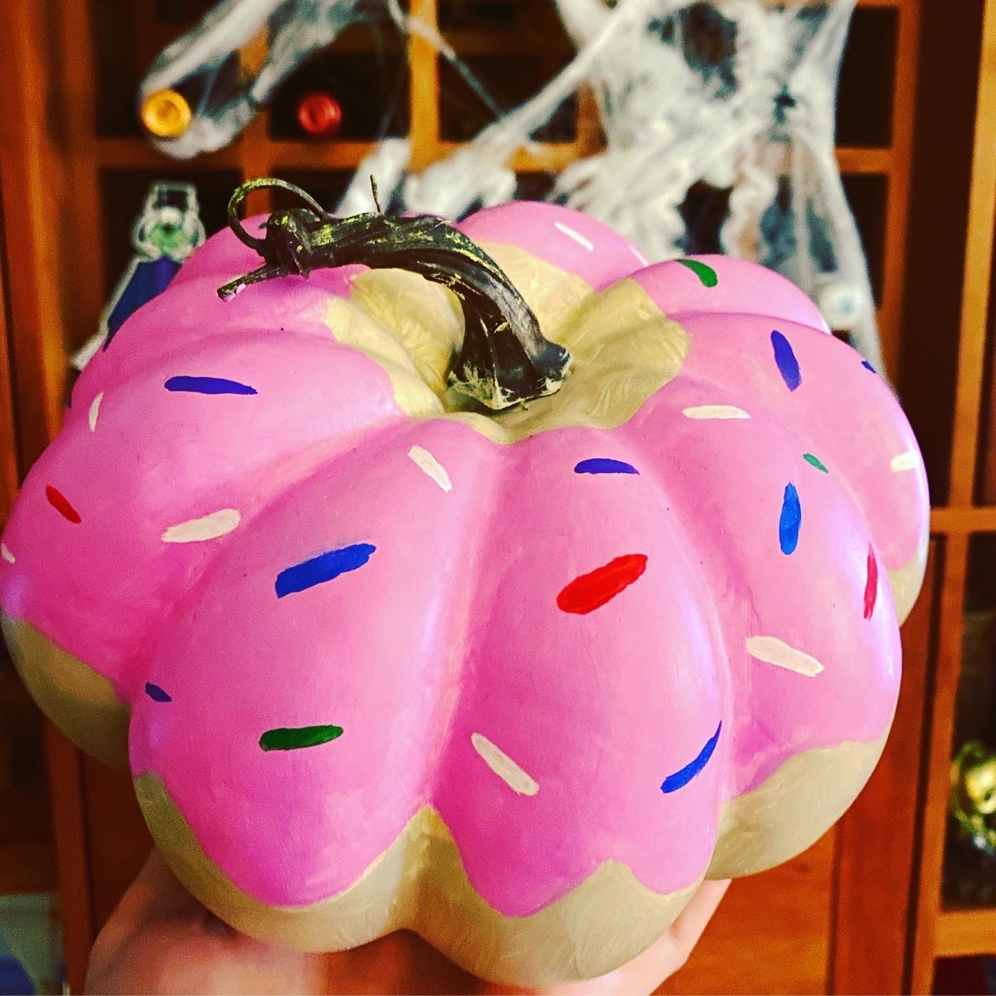 Painted pink donut pumpkin with sprinkles