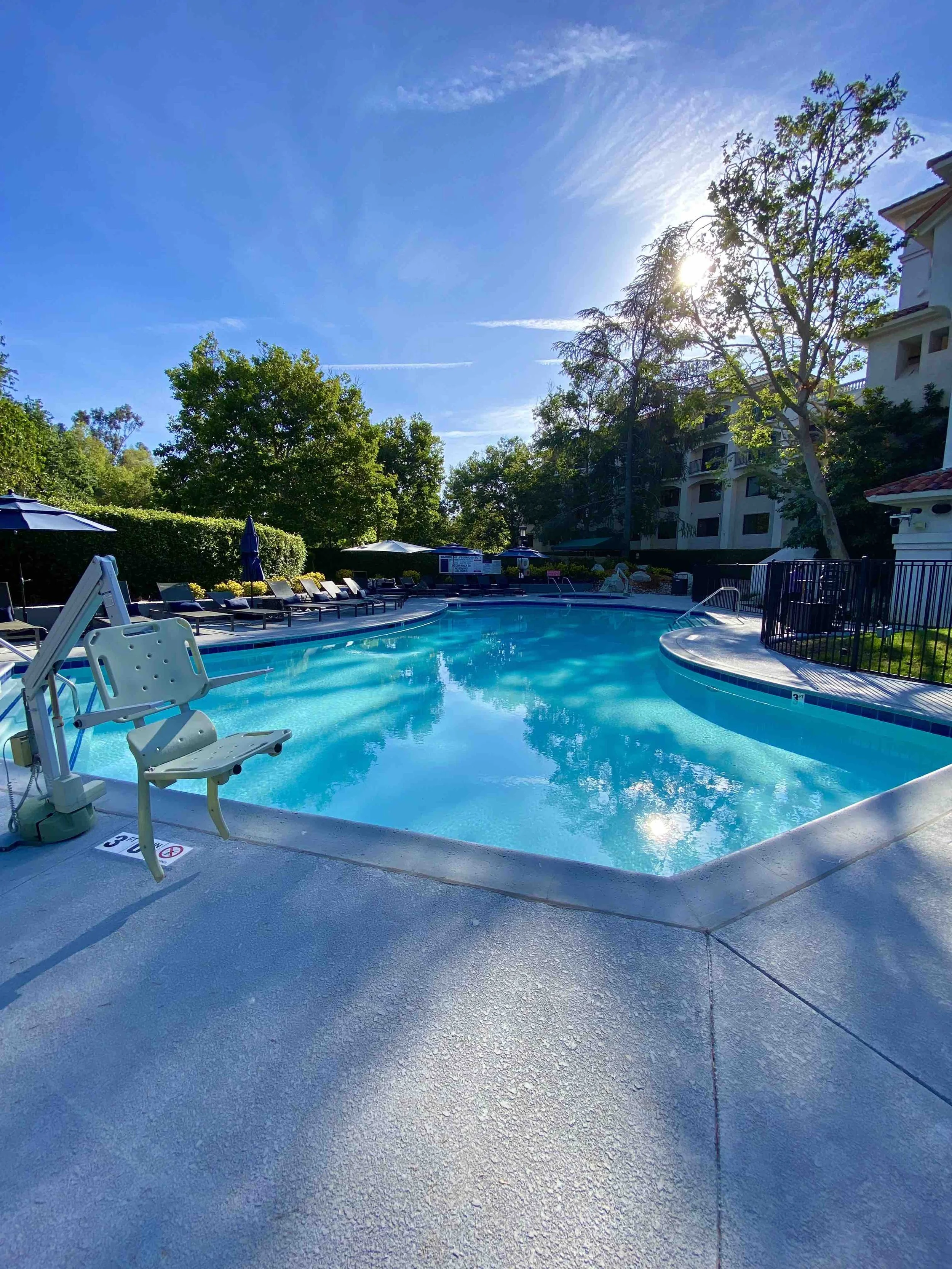 Outdoor swimming pool at Hyatt Regency Westlake in Westlake Village, California with lounge chairs and palm trees.