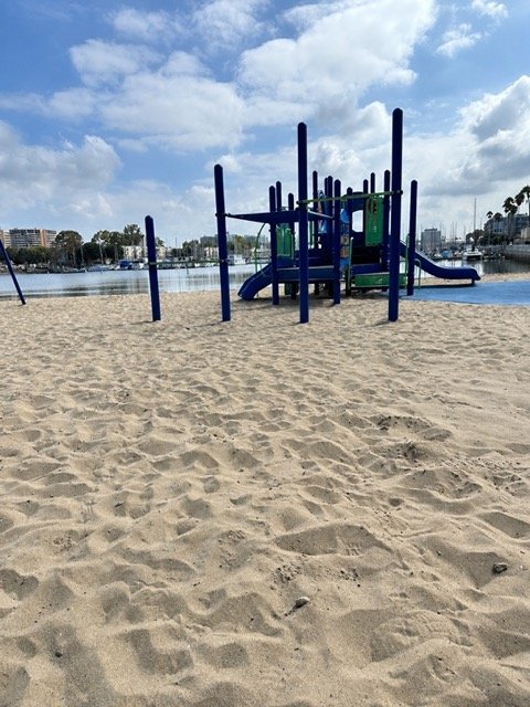 Mother's Beach playground at the beach and view of the boats in the marina