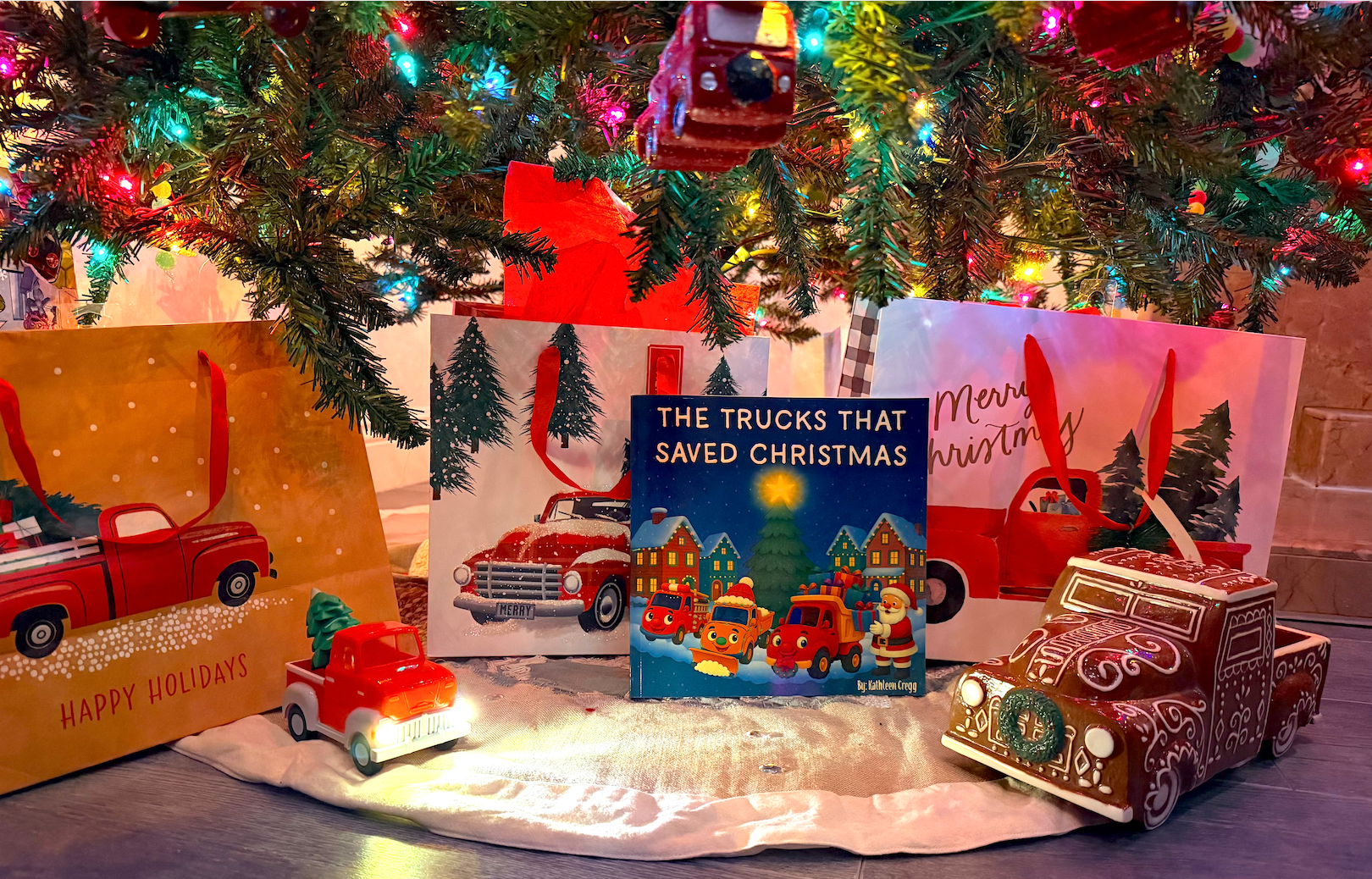 The Trucks That Saved Christmas children’s book displayed under a Christmas tree with festive gifts and toy trucks.