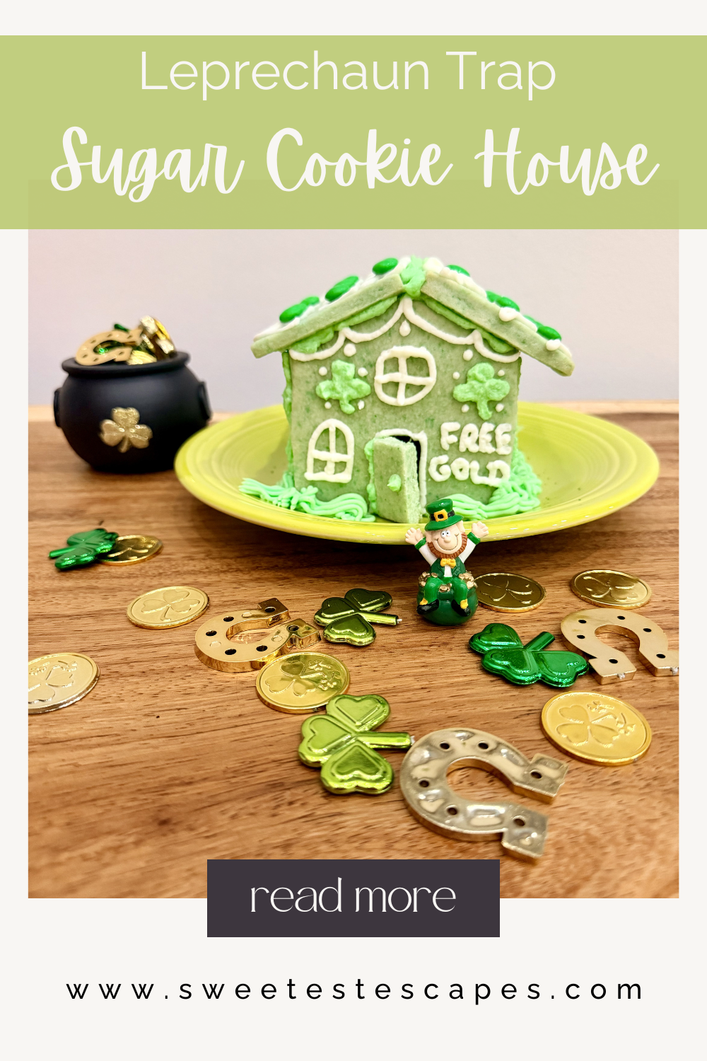 St. Patrick’s Day leprechaun trap sugar cookie house decorated with shamrocks and a “Free Gold” door, surrounded by gold coins and festive green decorations.