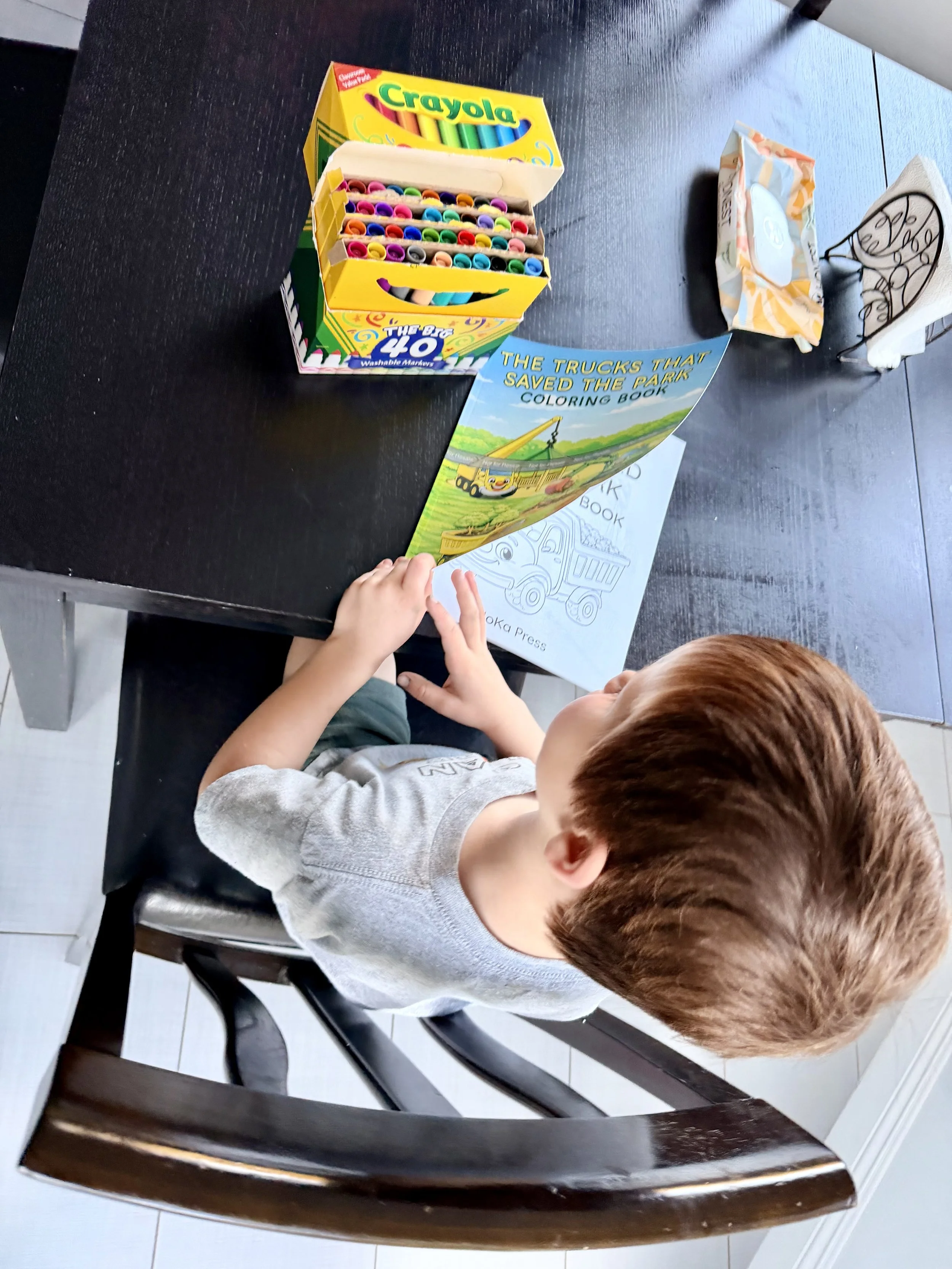 Earth Day coloring activity for kids using a construction truck themed coloring book and markers