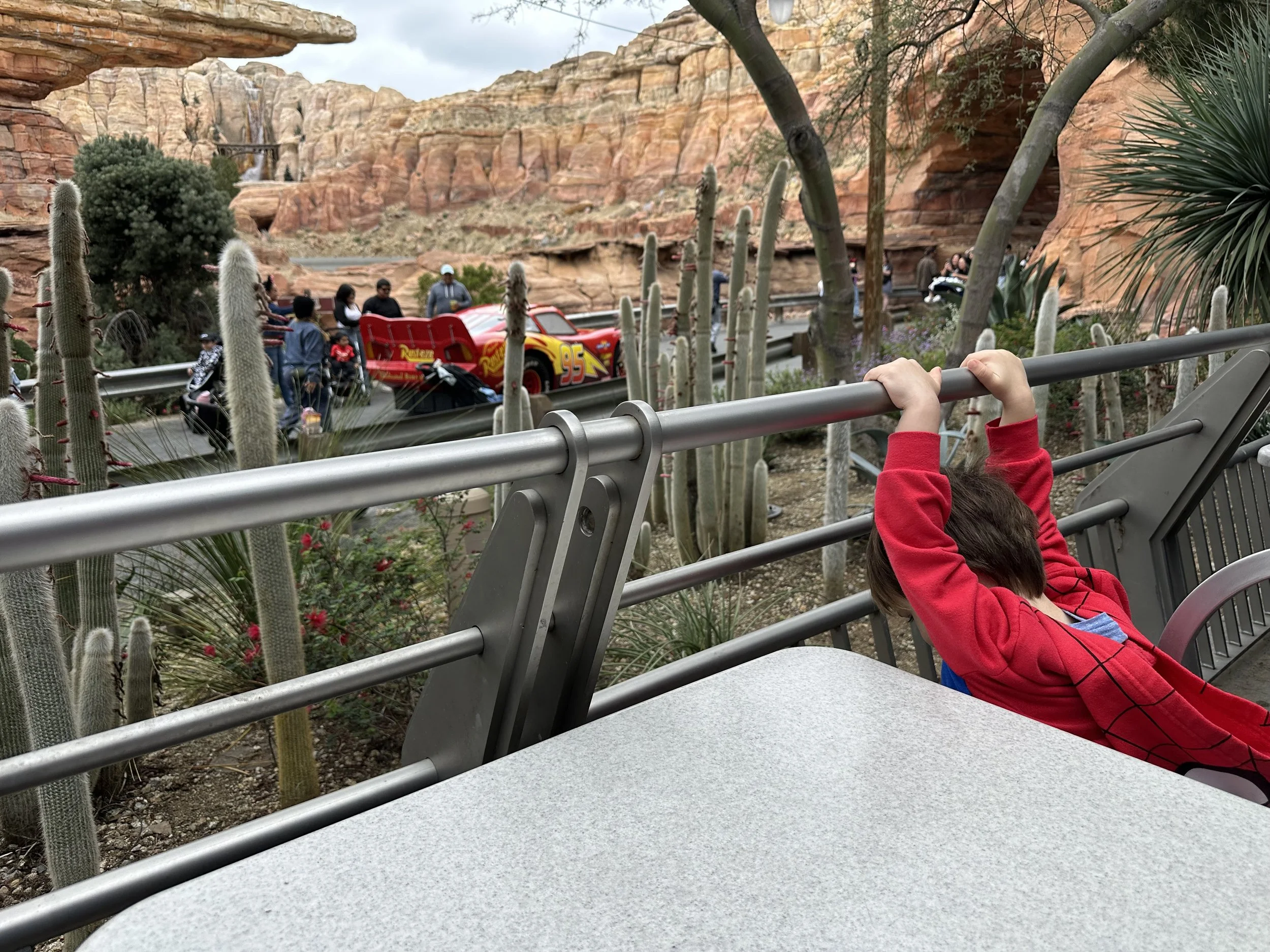 toddler eating at Flo's Cafe in California Adventure at the Disneyland Resort, watching Lightning McQueen cruise by.