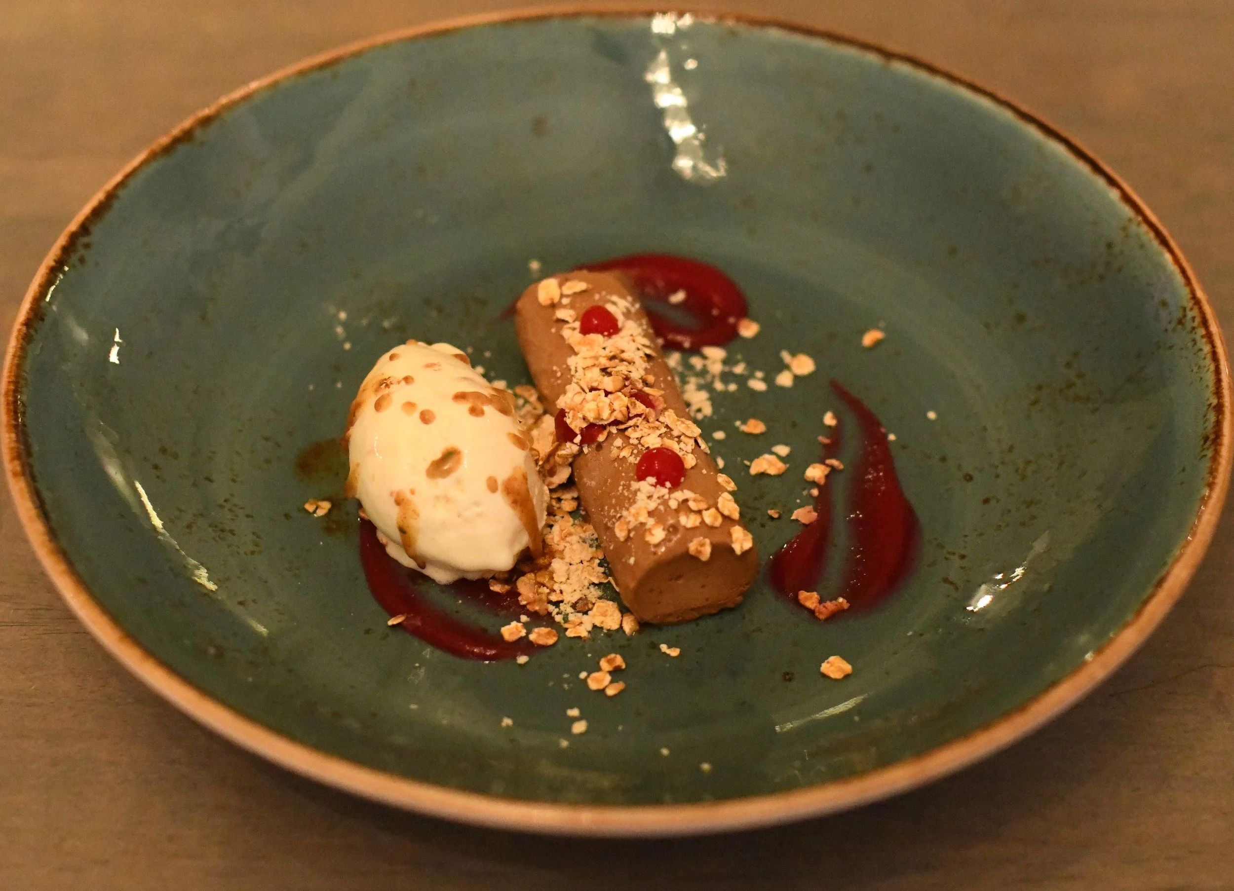 Sjokoladekrem, karamellisert hvit sjokolade, bakt havre , bringebær-rødbet gelé, serveres med vaniljeis toppet med brunet smør