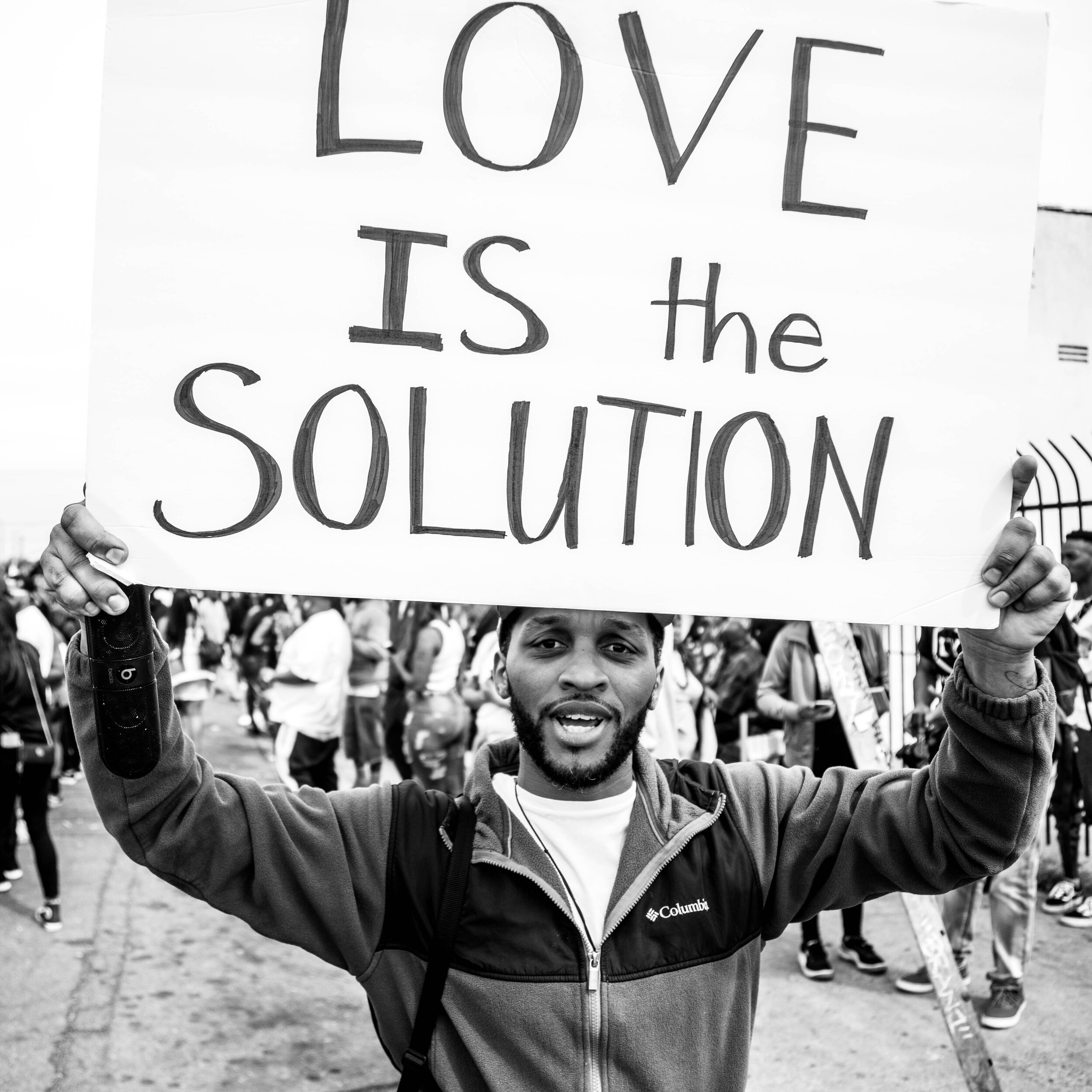  Matthew Sutton carries a sign reading “Love is The Solution.” As Sutton walked along the sidewalk, I saw him say, “I love you” to nearly every person he passed. When I snapped this picture, he yelled, “I love you too, cameraman!”  