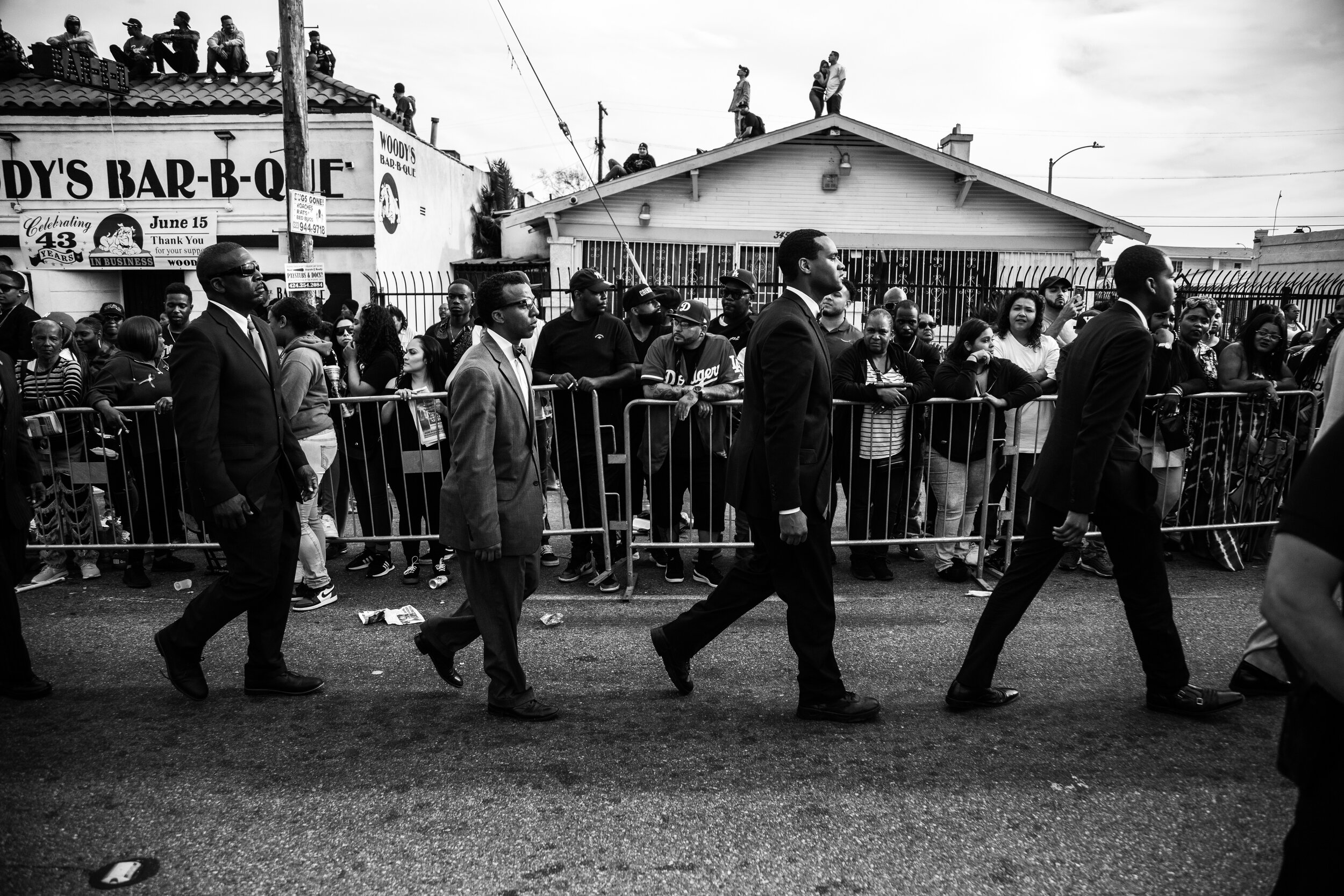  Members of the Fruit of Islam, which often provides private security at South Central events, prepare for the procession’s arrival at The Marathon Clothing Store.  