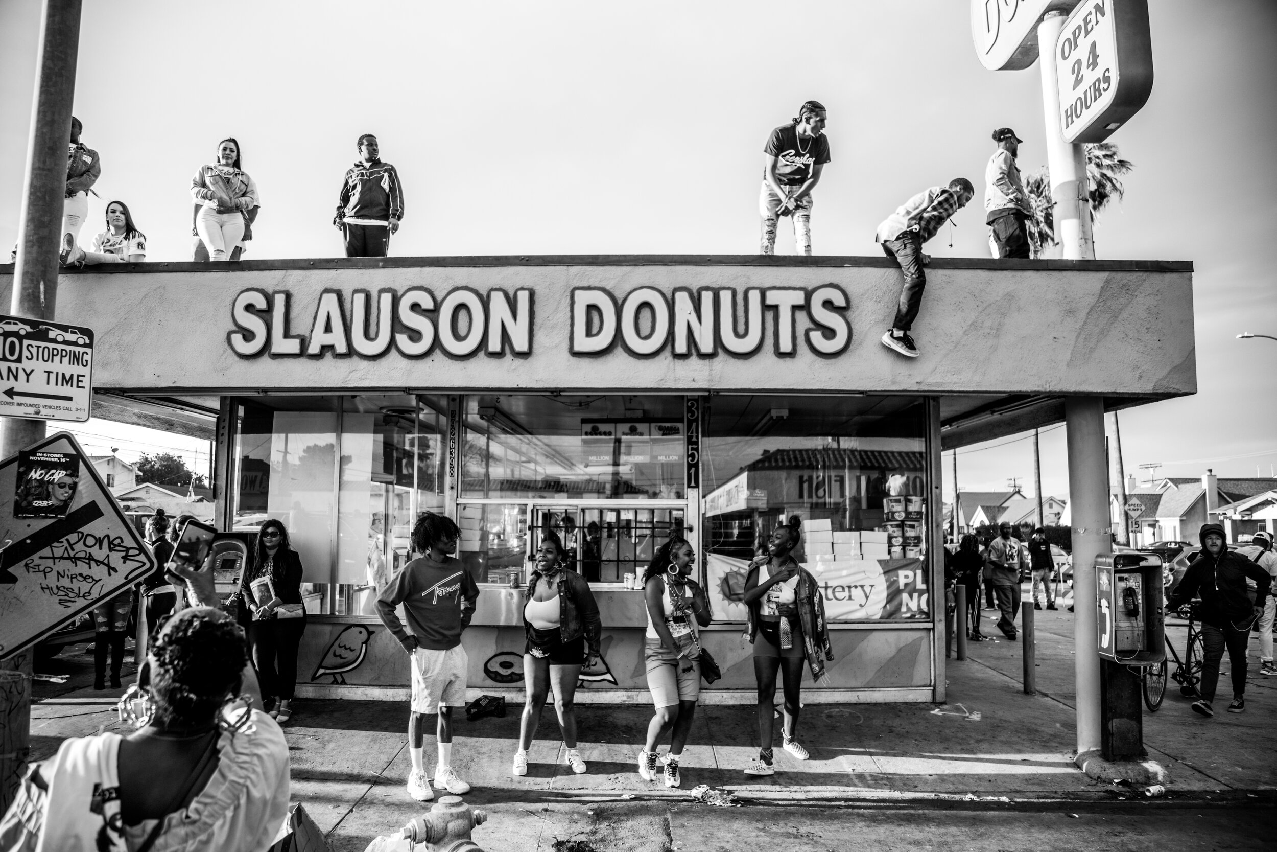  Fans and community members take it all in from the top of the Slauson Donuts building, located across the street from The Marathon Clothing Store. 